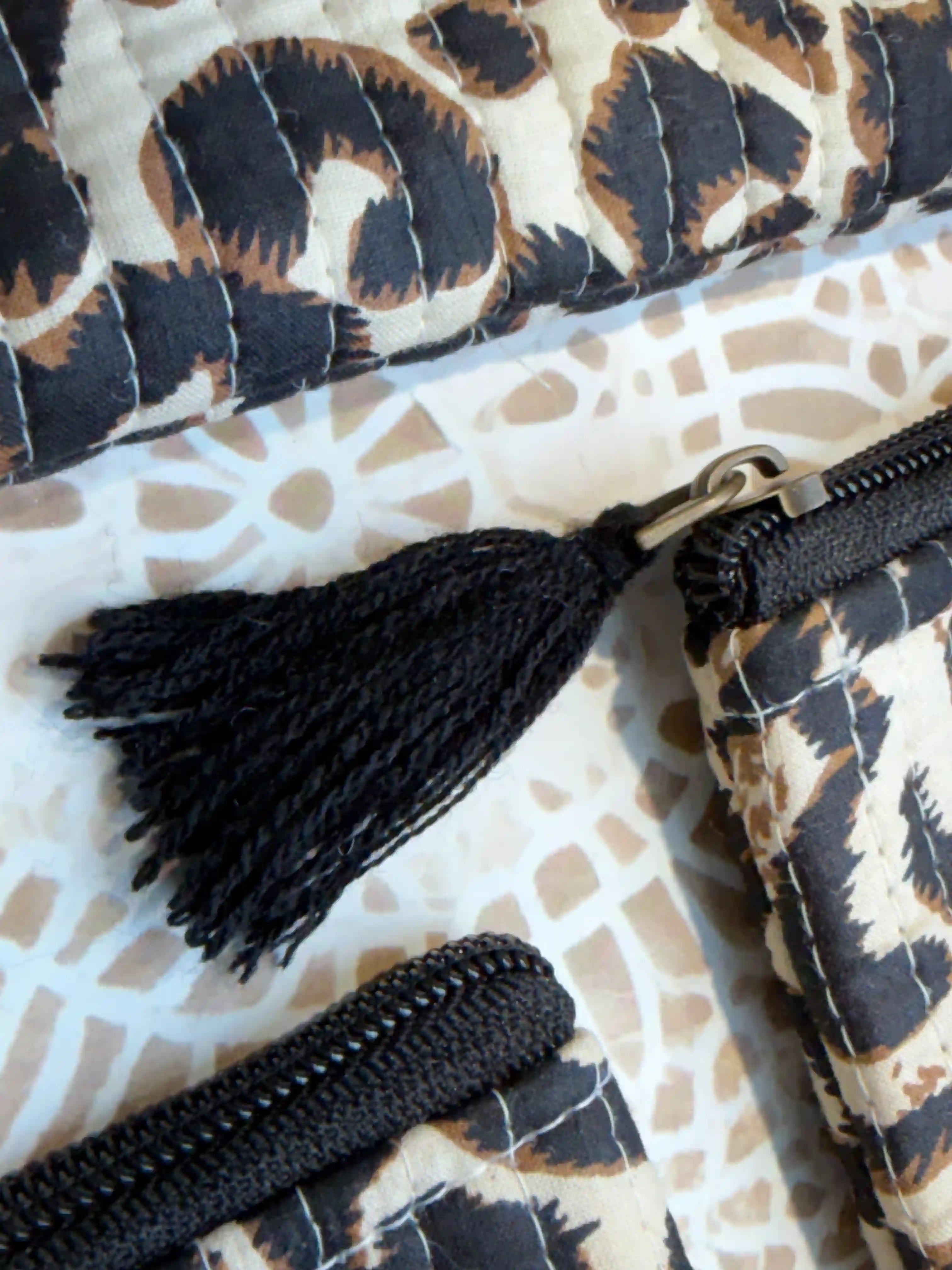 Beige quilted cotton flat pouch set with black leopard print hand block design, three-piece lightweight zipper organizer for travel and daily essentials.