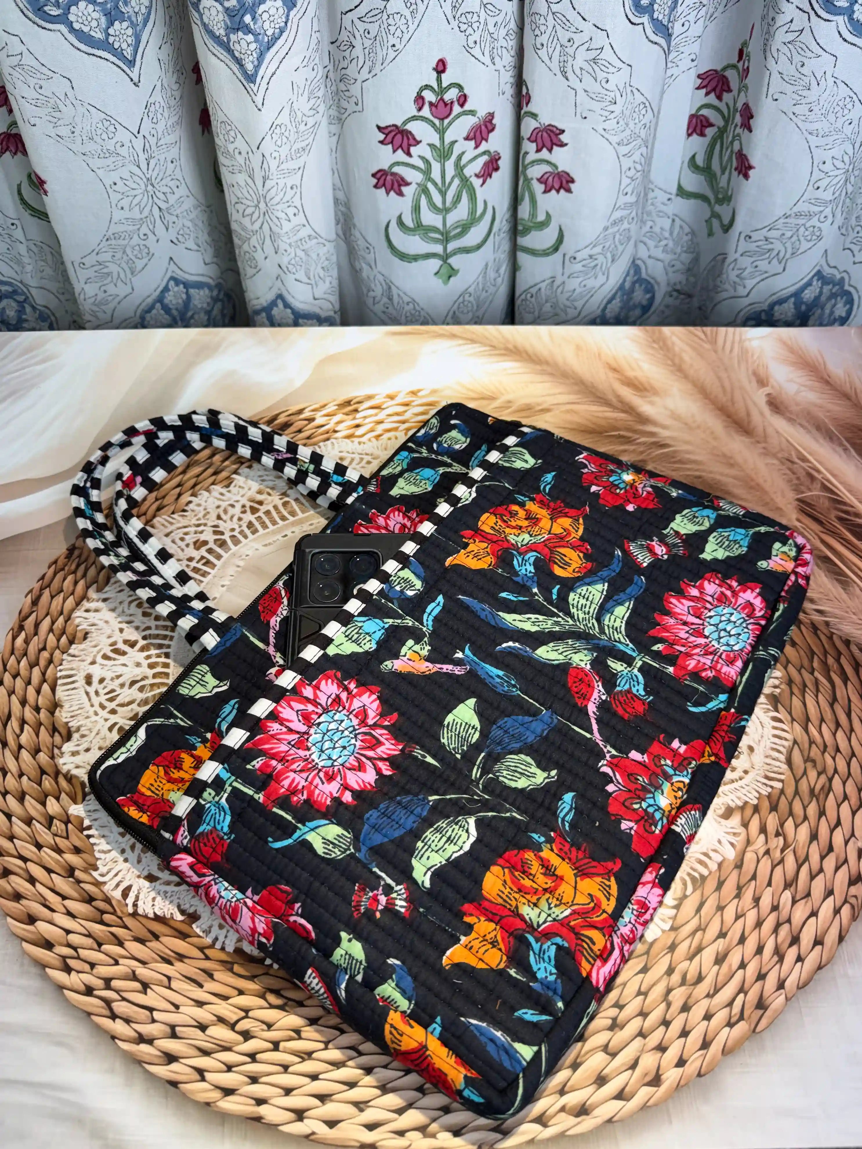Black quilted cotton laptop bag with multicolor floral hand block print and white striped borders, padded sleeve for 16-inch laptop