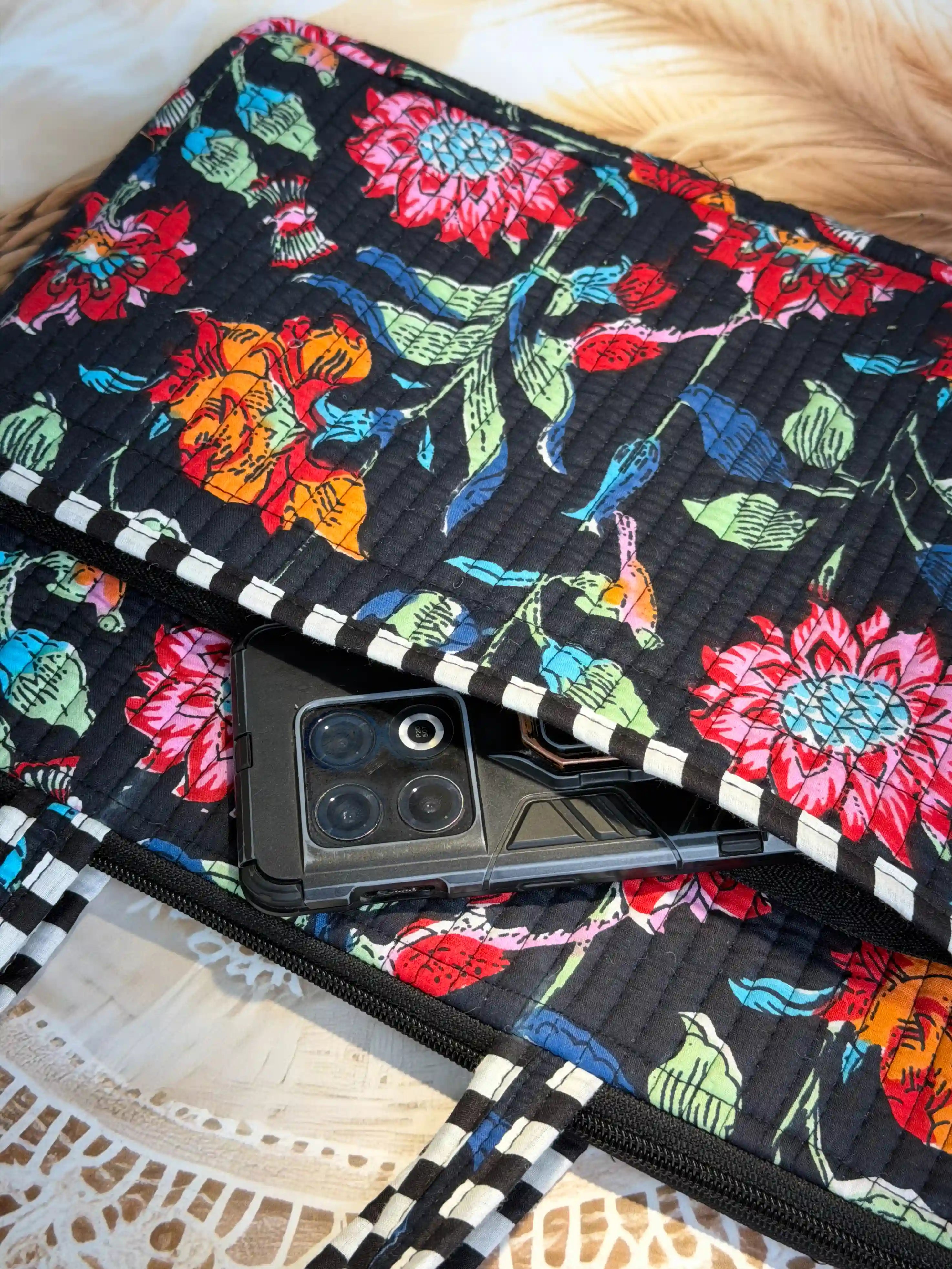 Black quilted cotton laptop bag with multicolor floral hand block print and white striped borders, padded sleeve for 16-inch laptop