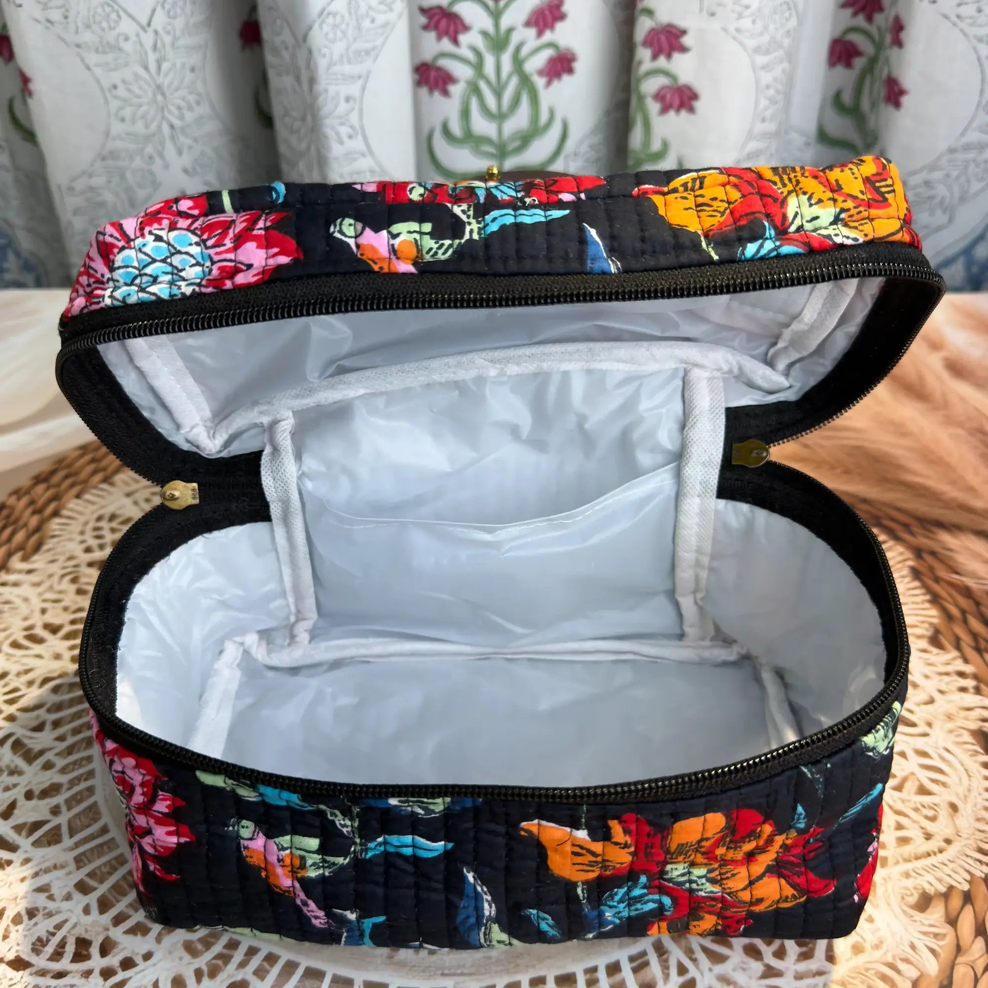 Black quilted cotton cosmetic vanity bag with multicolor floral hand block design and black interior, compact organizer for daily makeup and toiletries