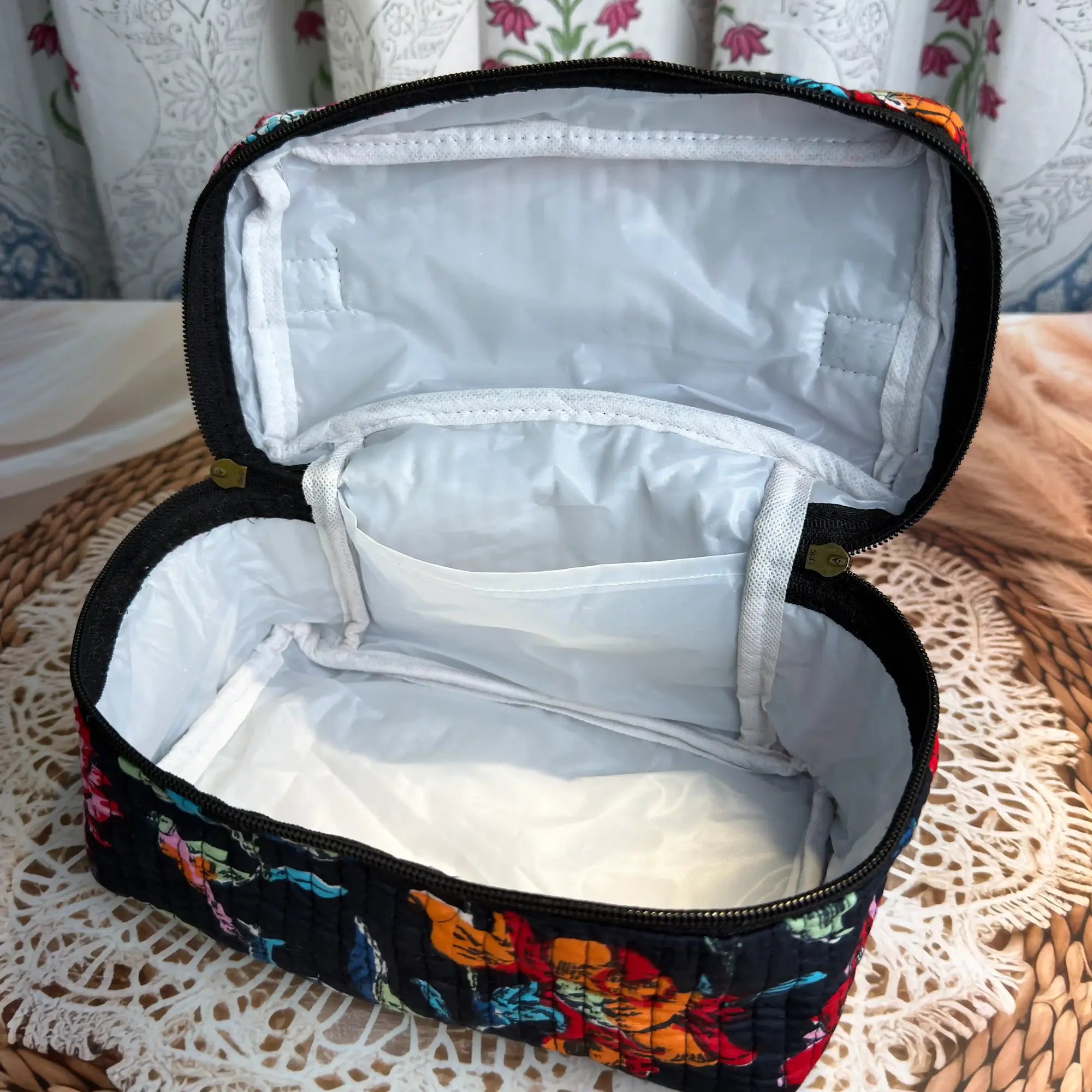 Black quilted cotton cosmetic vanity bag with multicolor floral hand block design and black interior, compact organizer for daily makeup and toiletries