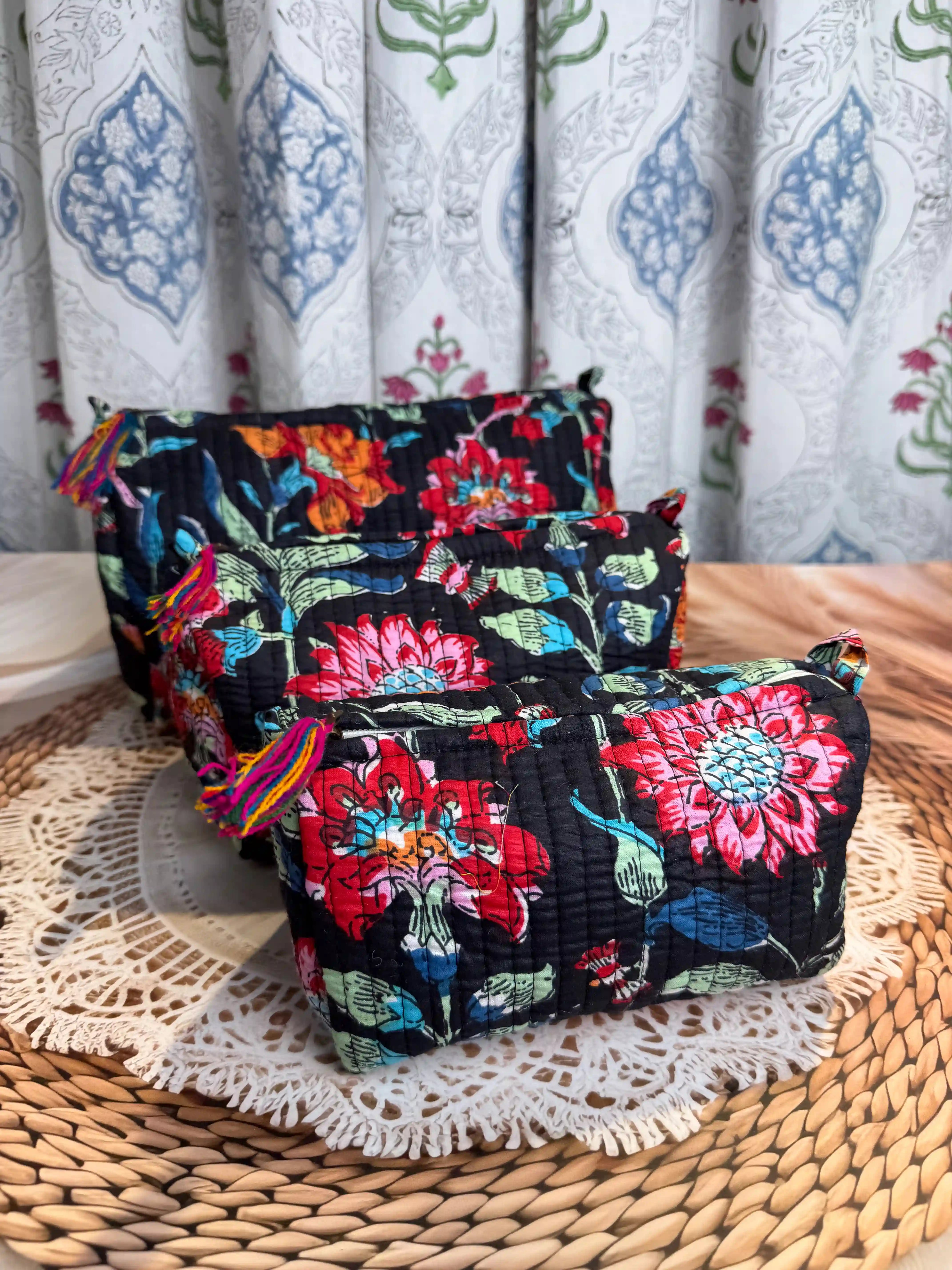 Black quilted cotton toiletry pouch set with vibrant red and orange multicolor floral hand block print, three-piece handmade travel organizer.
