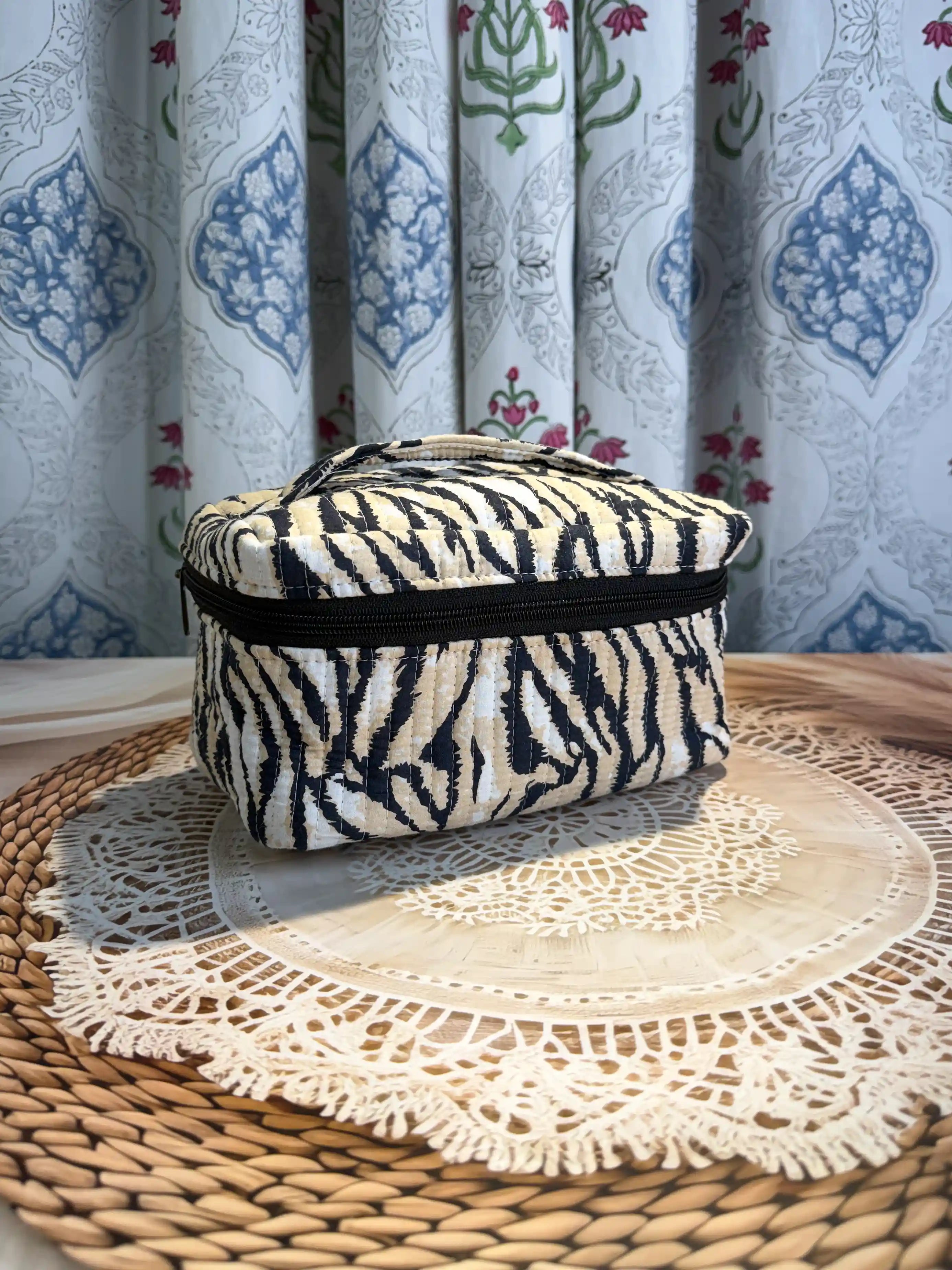 Black and cream quilted cotton cosmetic vanity bag with zebra stripe hand block pattern, animal print compact organizer for everyday cosmetics and essentials.
