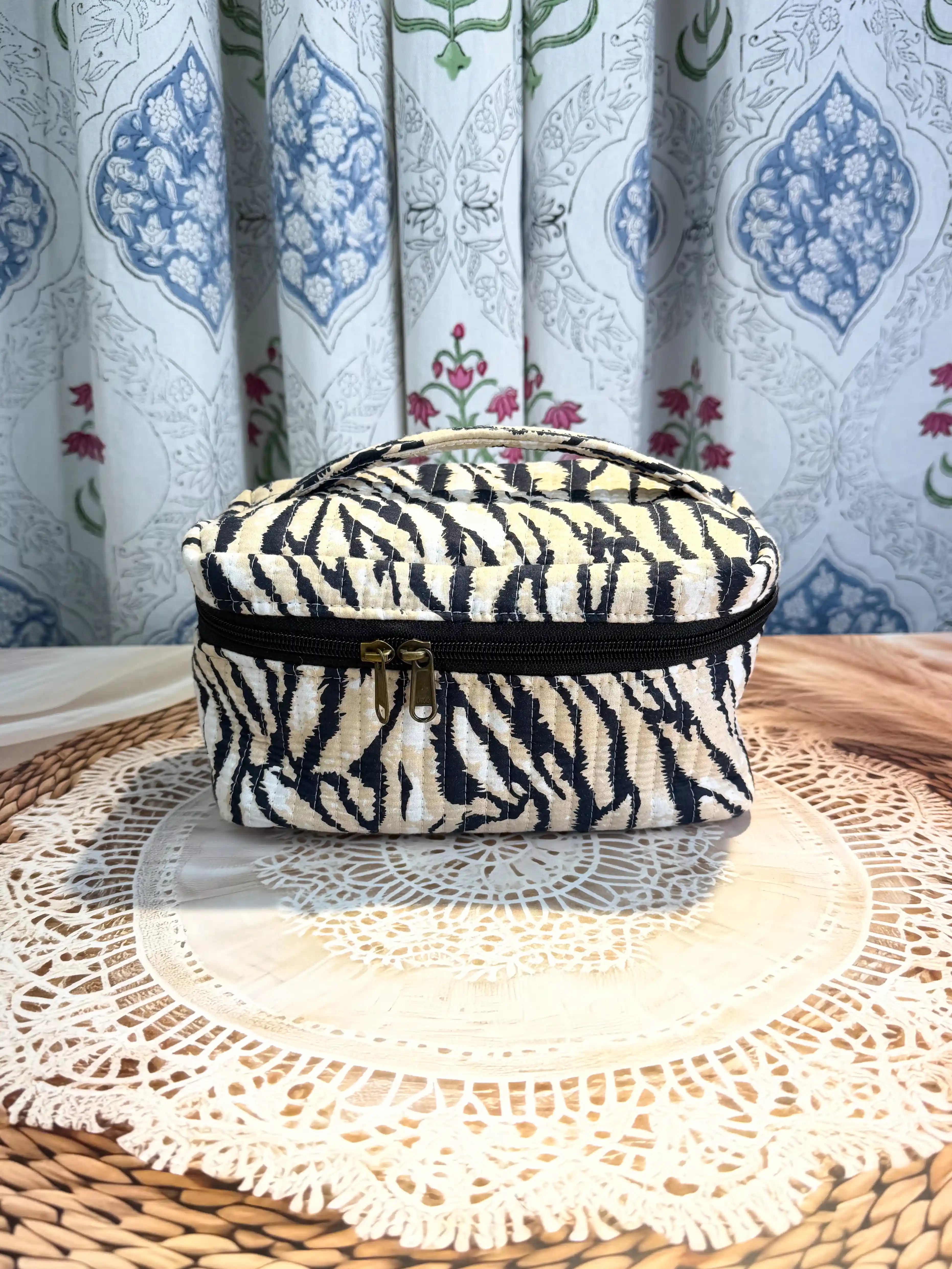 Black and cream quilted cotton cosmetic vanity bag with zebra stripe hand block pattern, animal print compact organizer for everyday cosmetics and essentials.