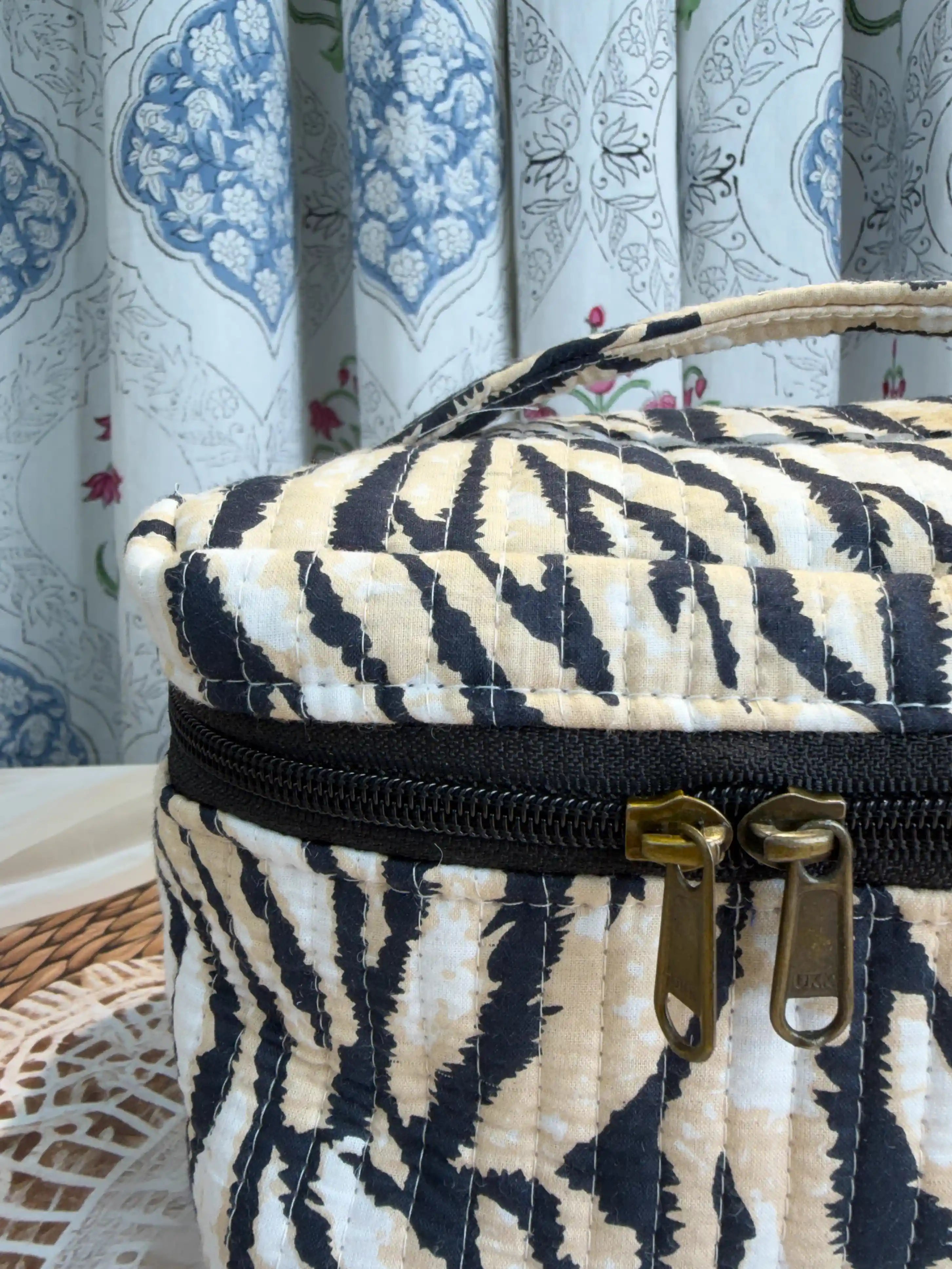 Black and cream quilted cotton cosmetic vanity bag with zebra stripe hand block pattern, animal print compact organizer for everyday cosmetics and essentials.