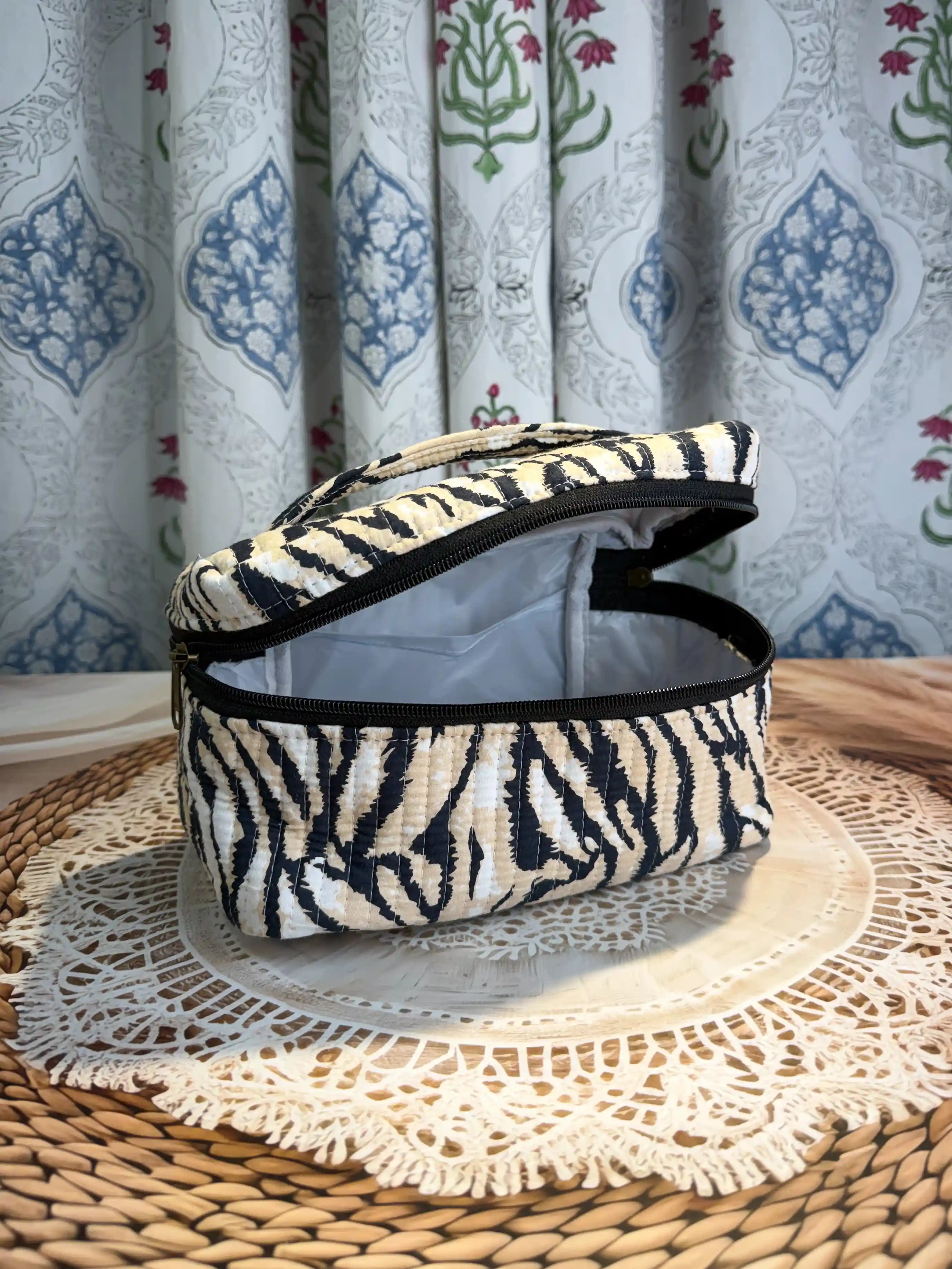 Black and cream quilted cotton cosmetic vanity bag with zebra stripe hand block pattern, animal print compact organizer for everyday cosmetics and essentials.