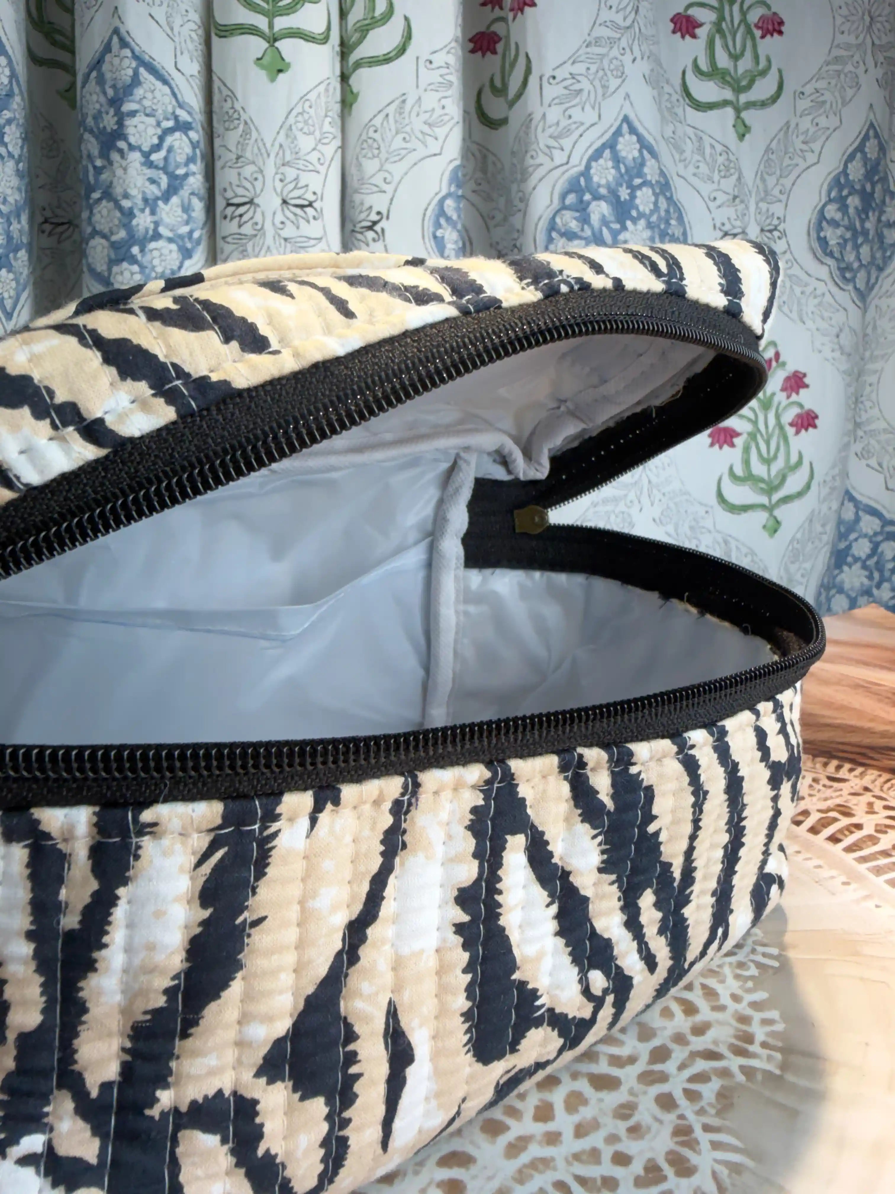 Black and cream quilted cotton cosmetic vanity bag with zebra stripe hand block pattern, animal print compact organizer for everyday cosmetics and essentials.