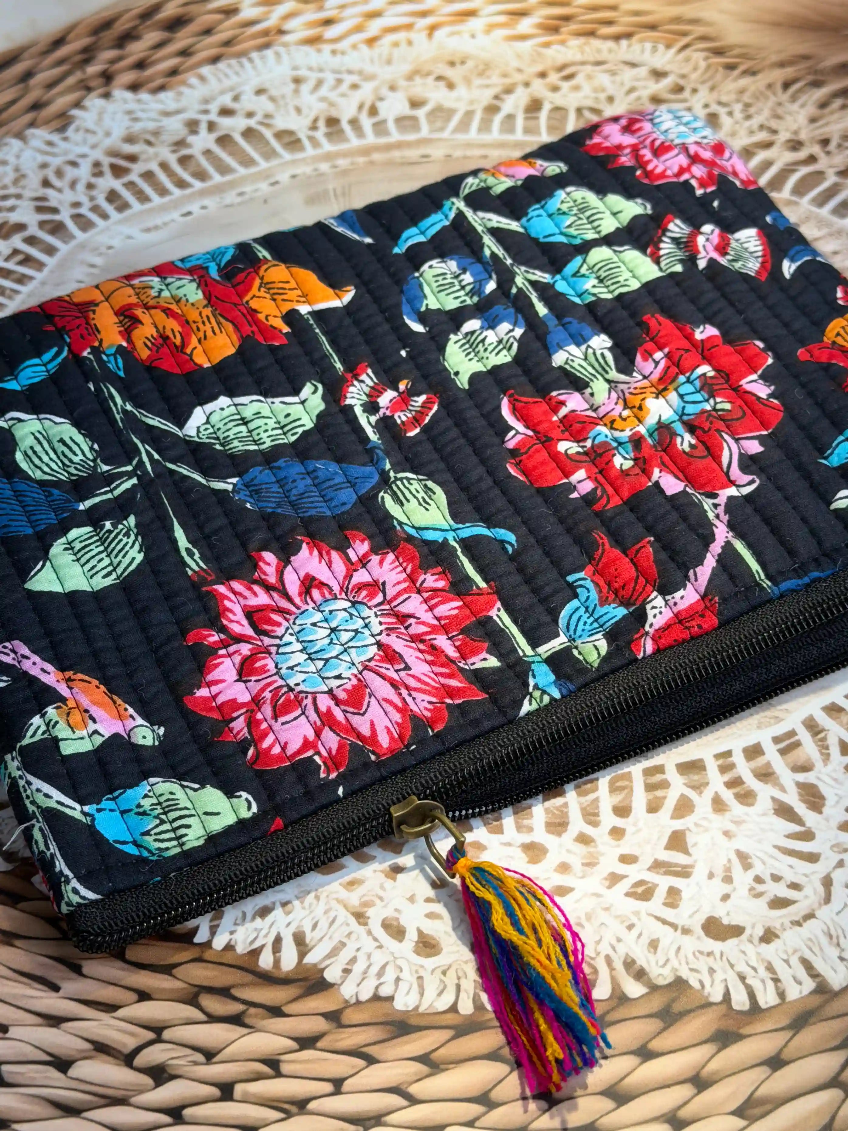 Black quilted cotton flat pouch set with red and orange multicolor floral hand block print, three-piece handcrafted zipper pouches for organization.