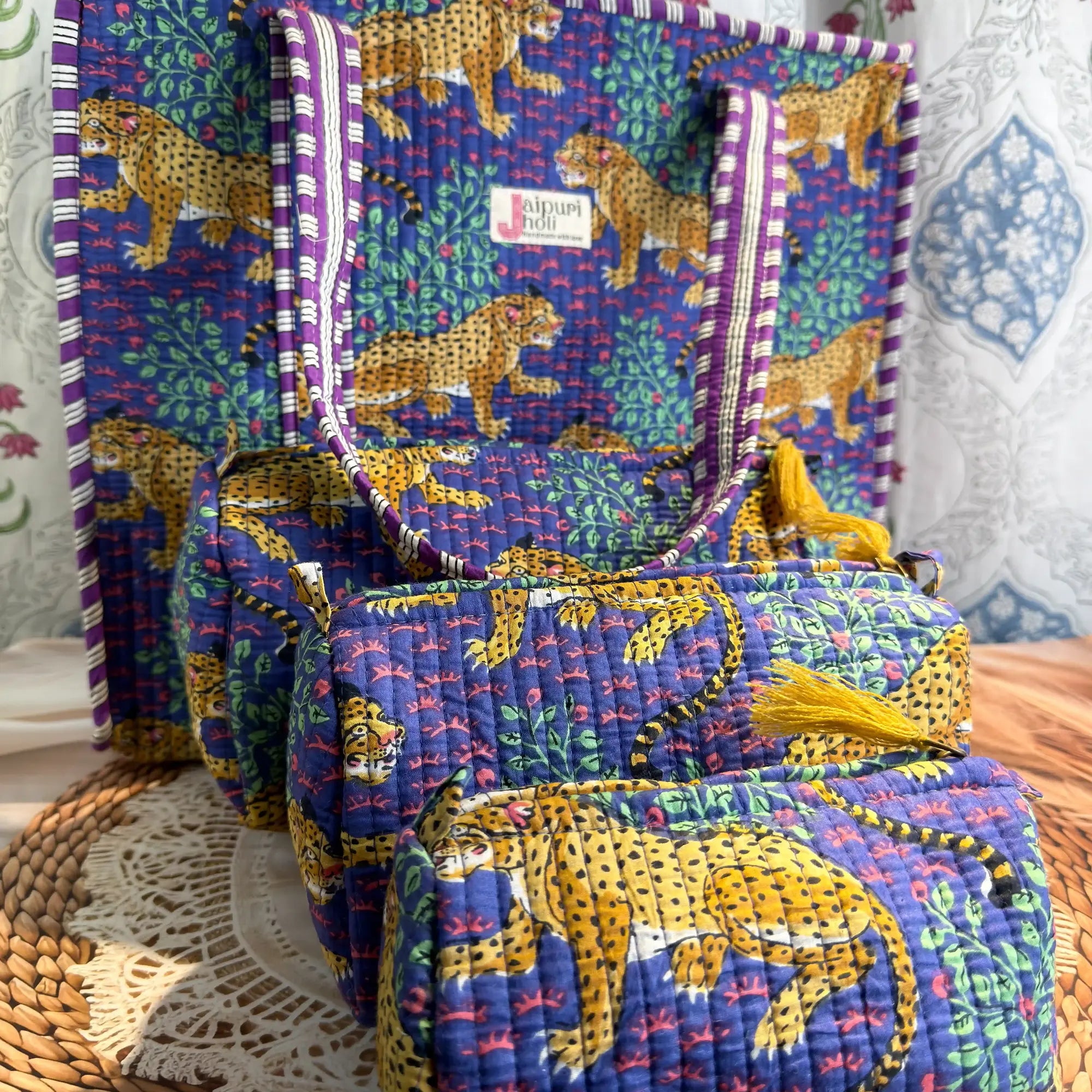 Handcrafted blue cotton quilted tote bag with leopard print design and sturdy striped handles, paired with a matching 3-piece zippered toiletry pouch set, featuring soft quilted texture, single compartments, and ethnic Jaipur craftsmanship, ideal for everyday use, travel, cosmetics, skincare, and innerwear storage
