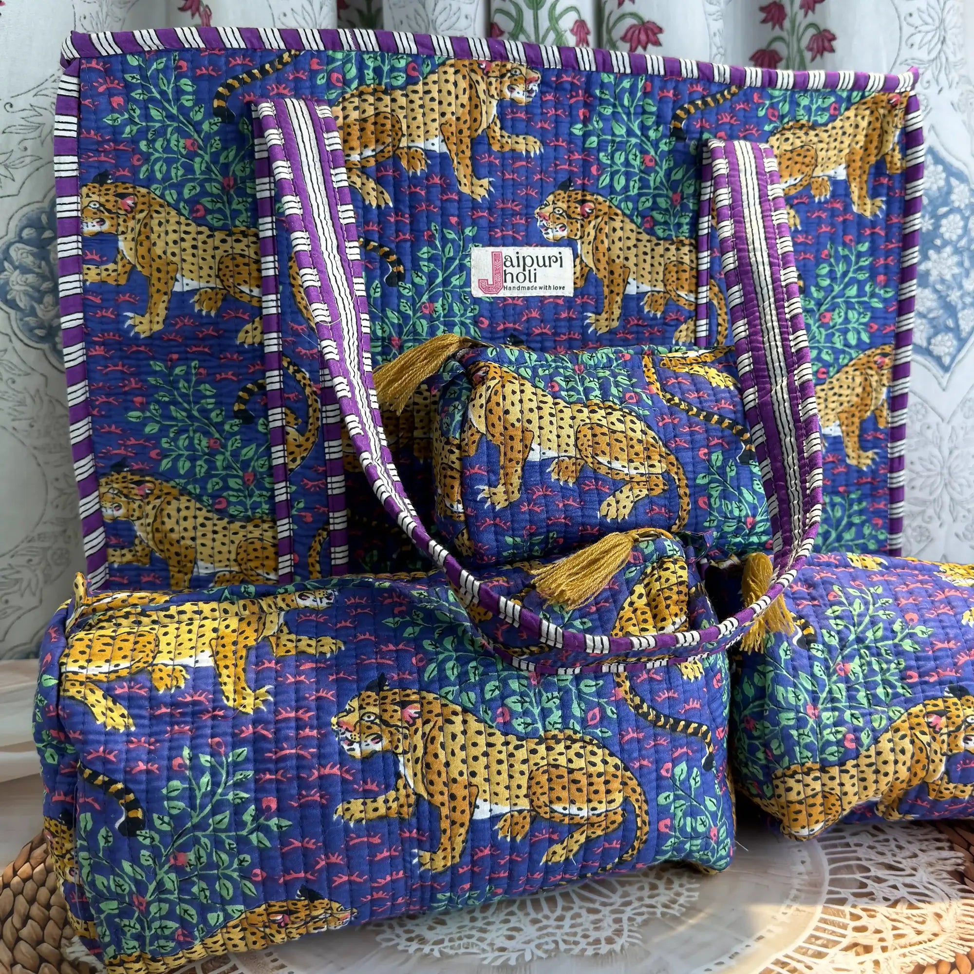 Handcrafted blue cotton quilted tote bag with leopard print design and sturdy striped handles, paired with a matching 3-piece zippered toiletry pouch set, featuring soft quilted texture, single compartments, and ethnic Jaipur craftsmanship, ideal for everyday use, travel, cosmetics, skincare, and innerwear storage