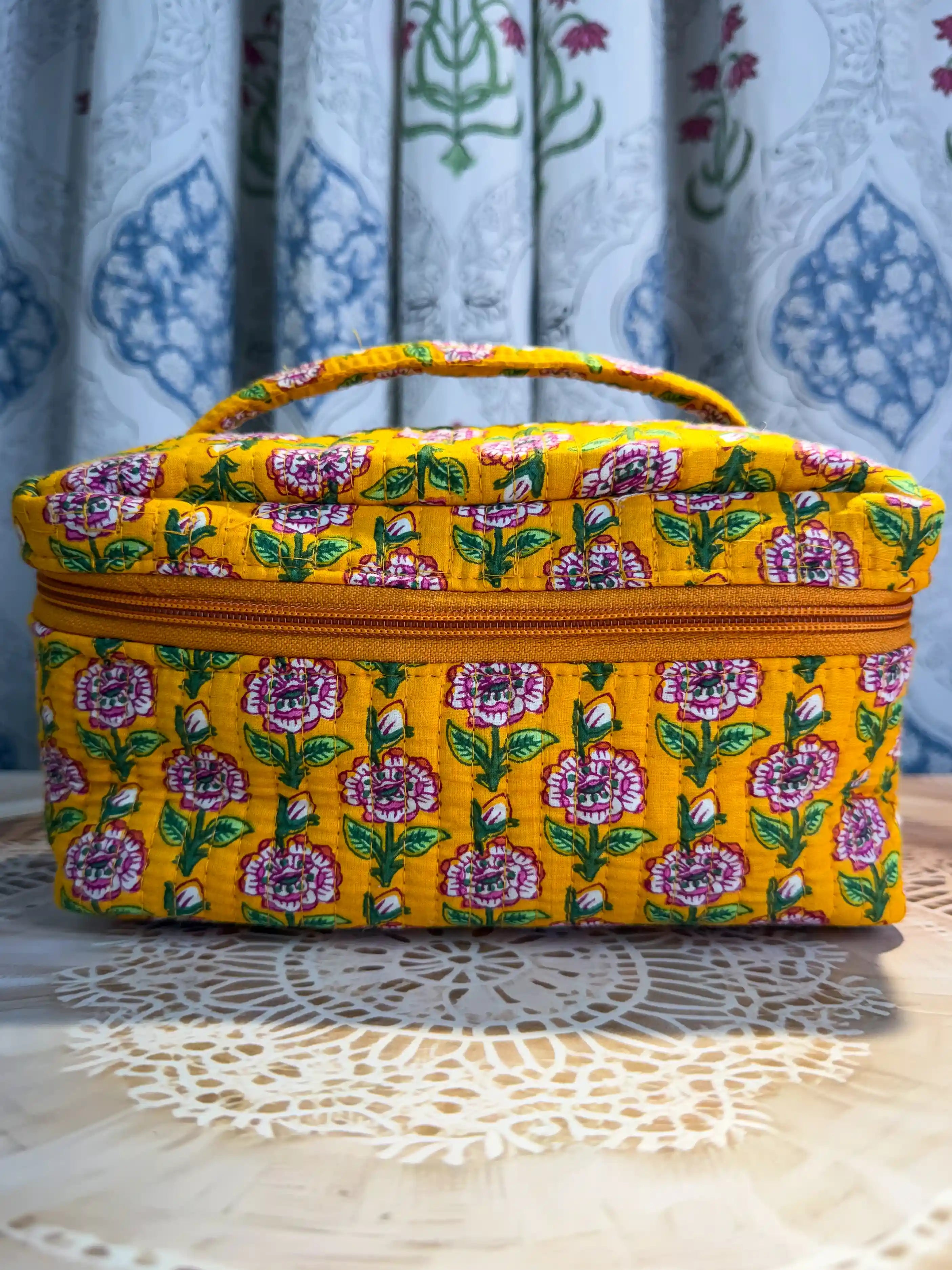 Bright yellow quilted cotton cosmetic vanity bag with purple and green multicolor floral hand block design, cheerful handcrafted makeup organizer for daily use