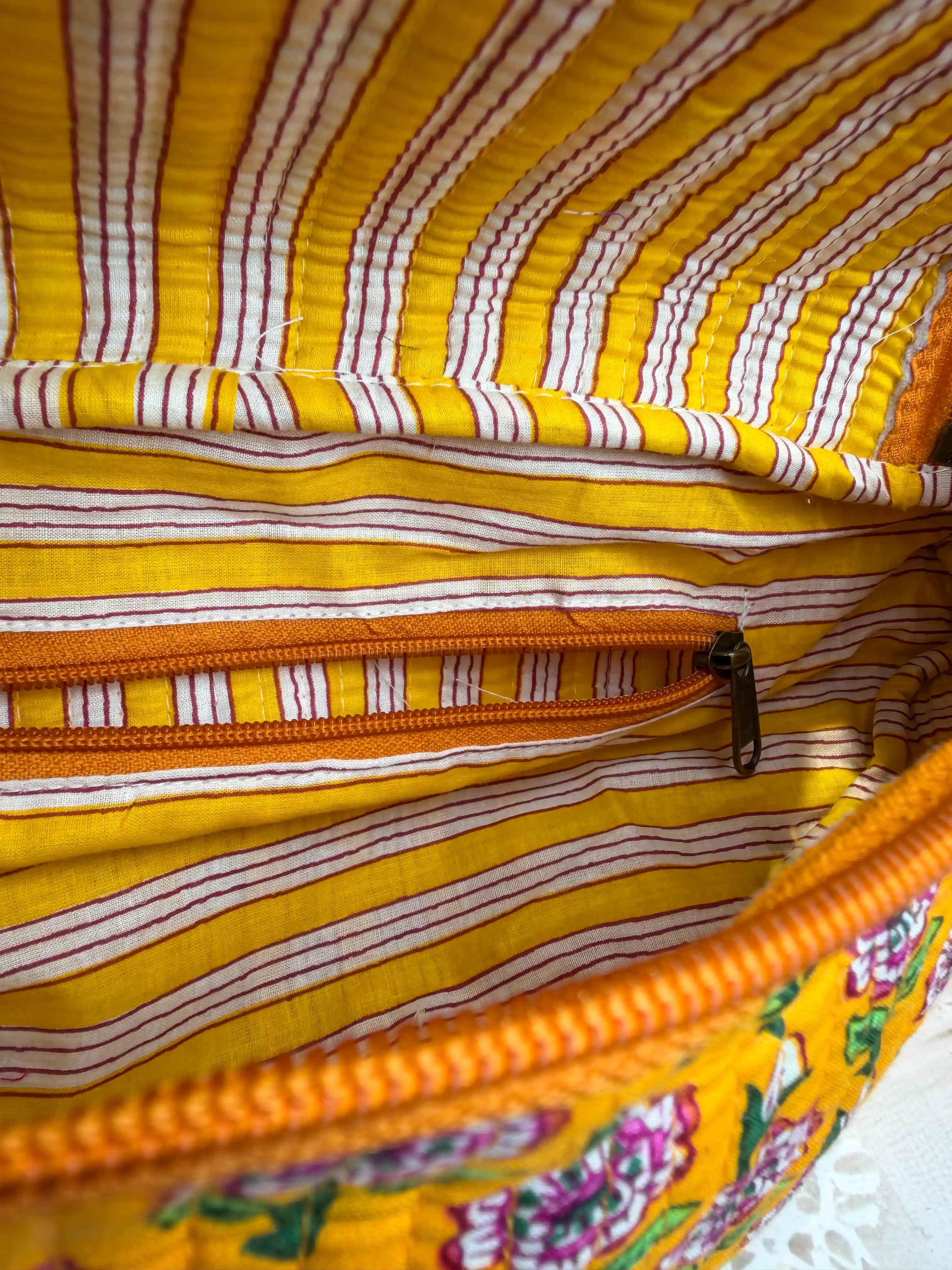Bright yellow quilted cotton fanny bag with purple and green multicolor floral hand block print, striped waist strap for daily and travel use