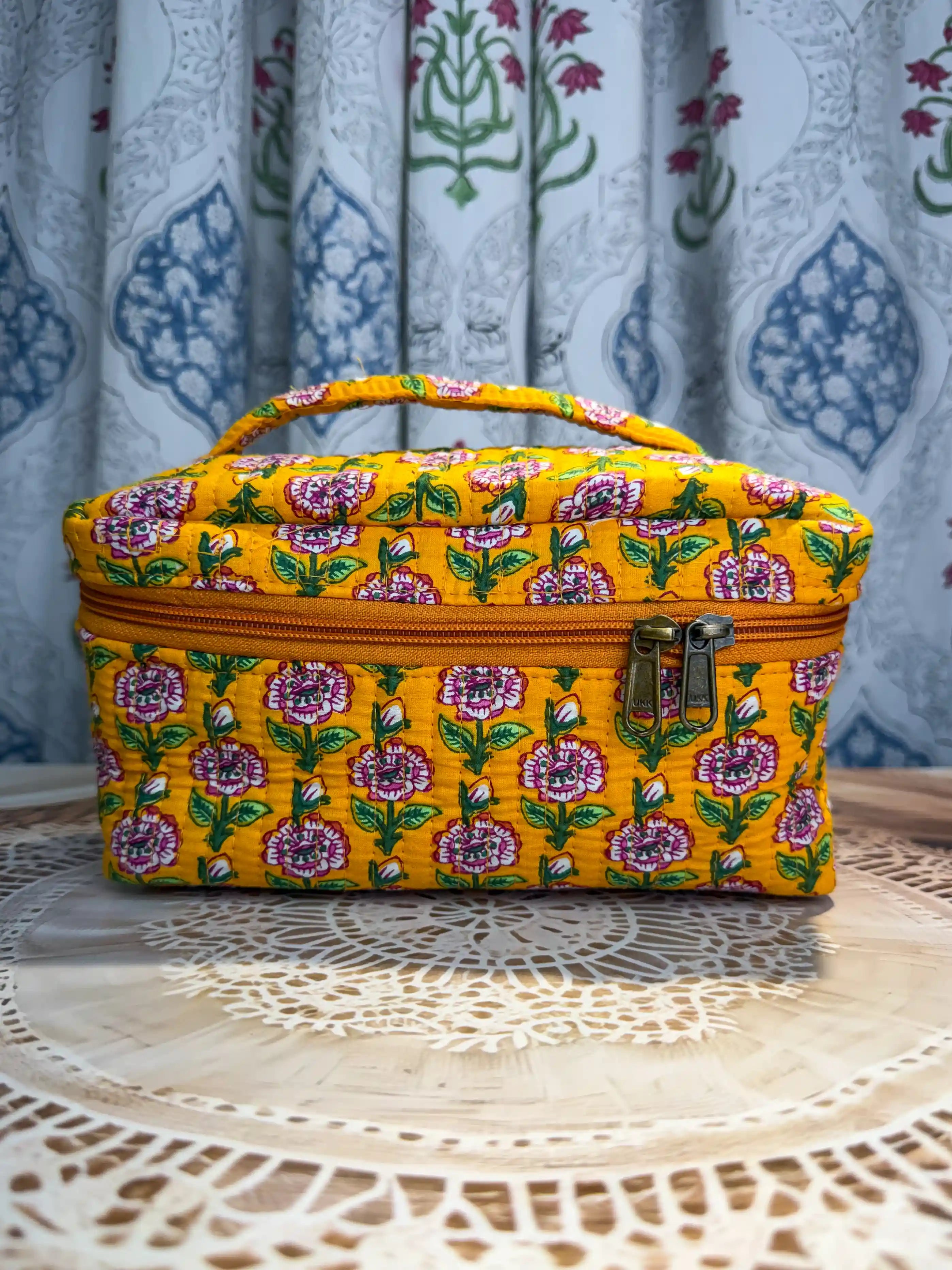 Bright yellow quilted cotton cosmetic vanity bag with purple and green multicolor floral hand block design, cheerful handcrafted makeup organizer for daily use
