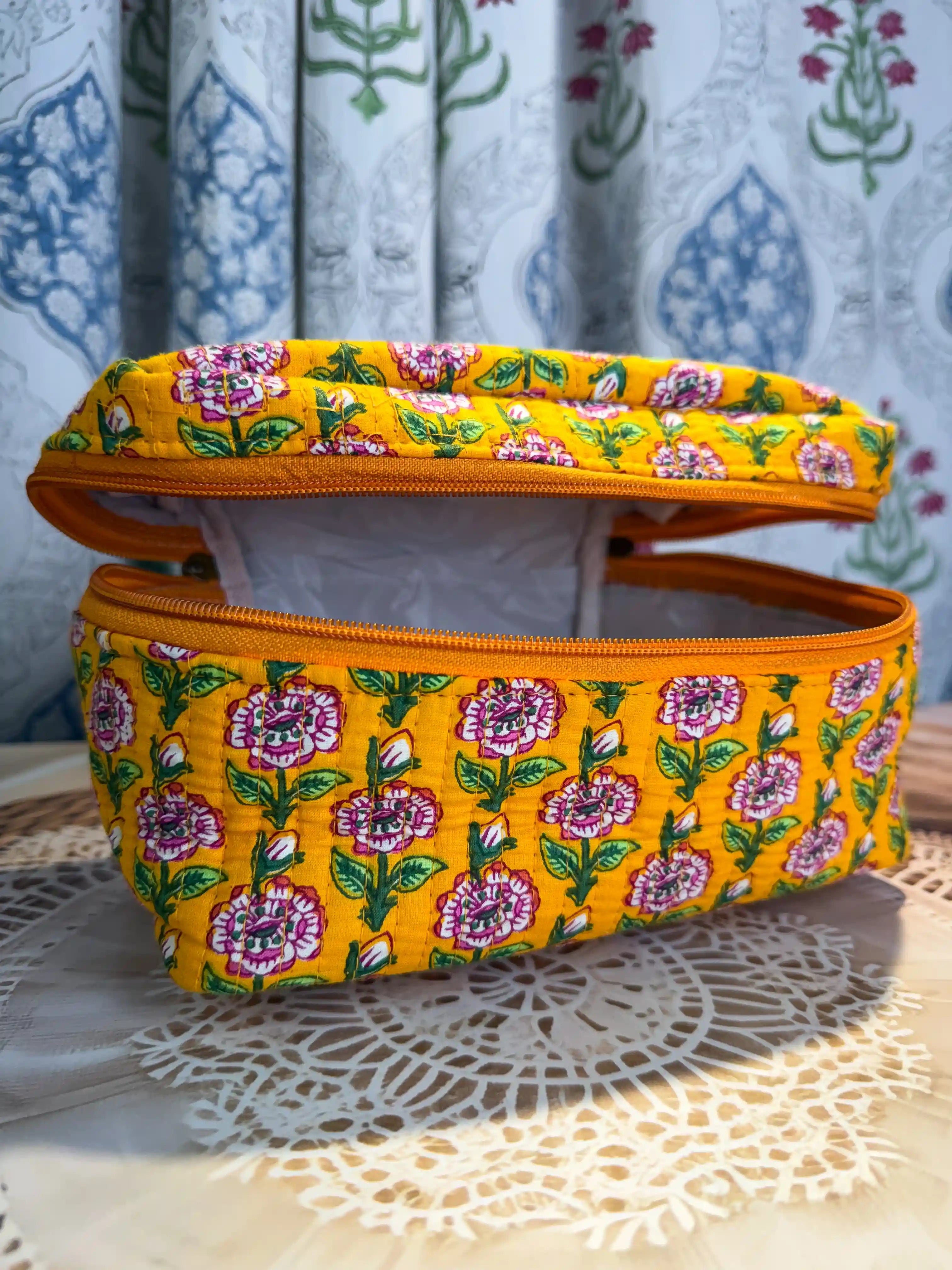 Bright yellow quilted cotton cosmetic vanity bag with purple and green multicolor floral hand block design, cheerful handcrafted makeup organizer for daily use