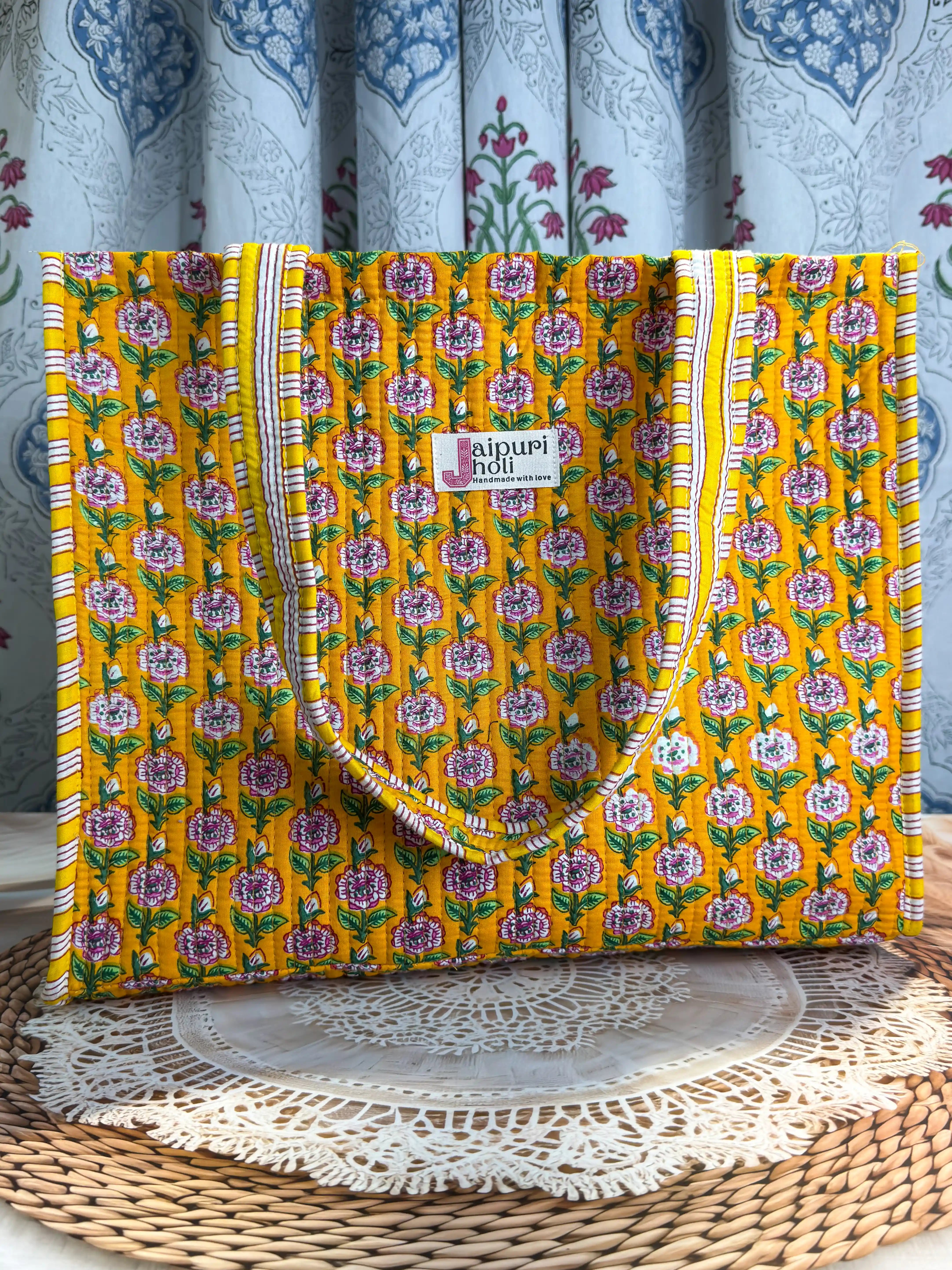Bright yellow quilted cotton tote bag with multicolor floral hand block design, striped borders, and zip, cheerful handcrafted carryall for daily use.