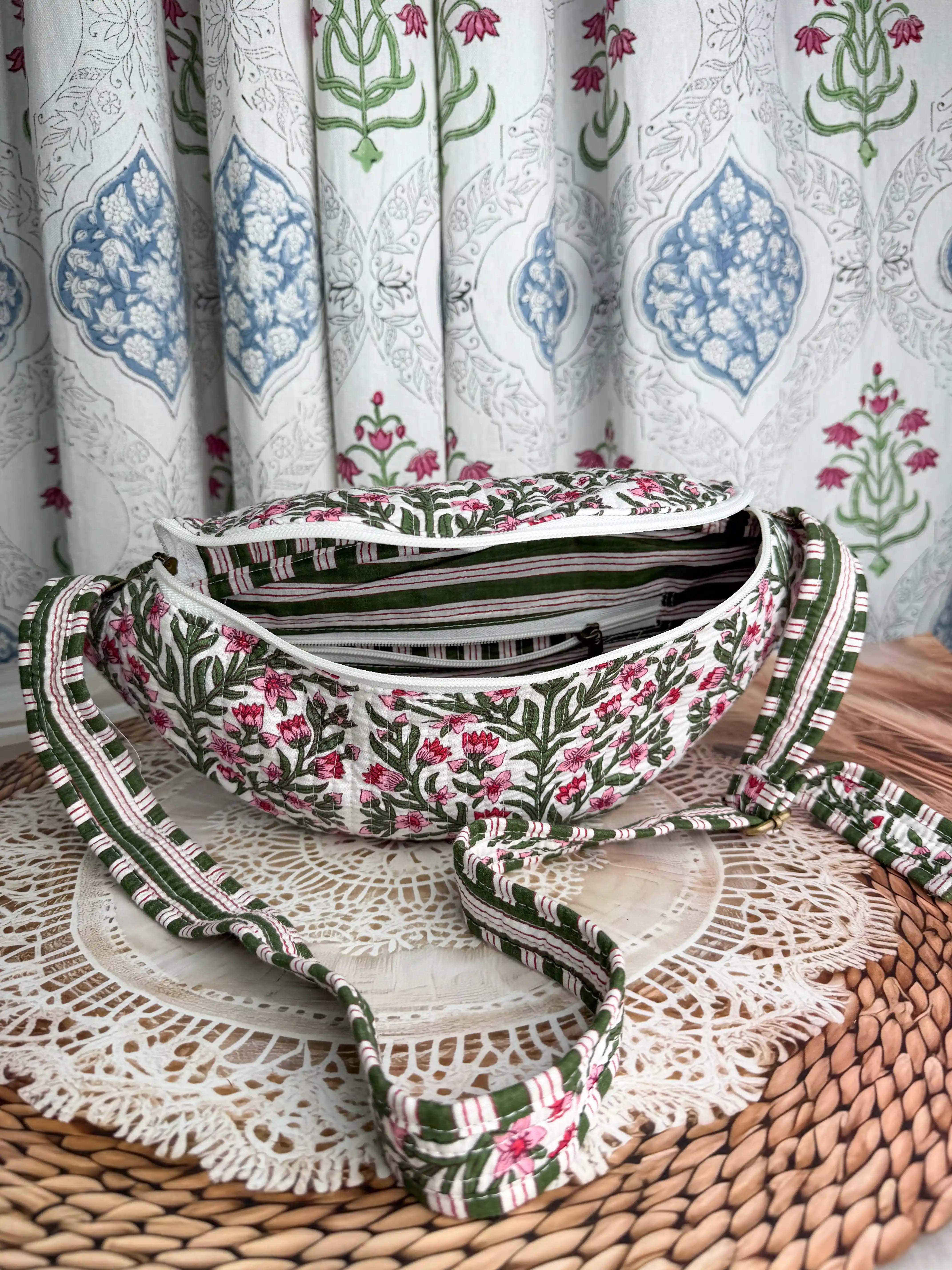 Cream quilted cotton fanny bag with red and green botanical floral hand block design, multicolor striped strap for hands-free everyday wear.