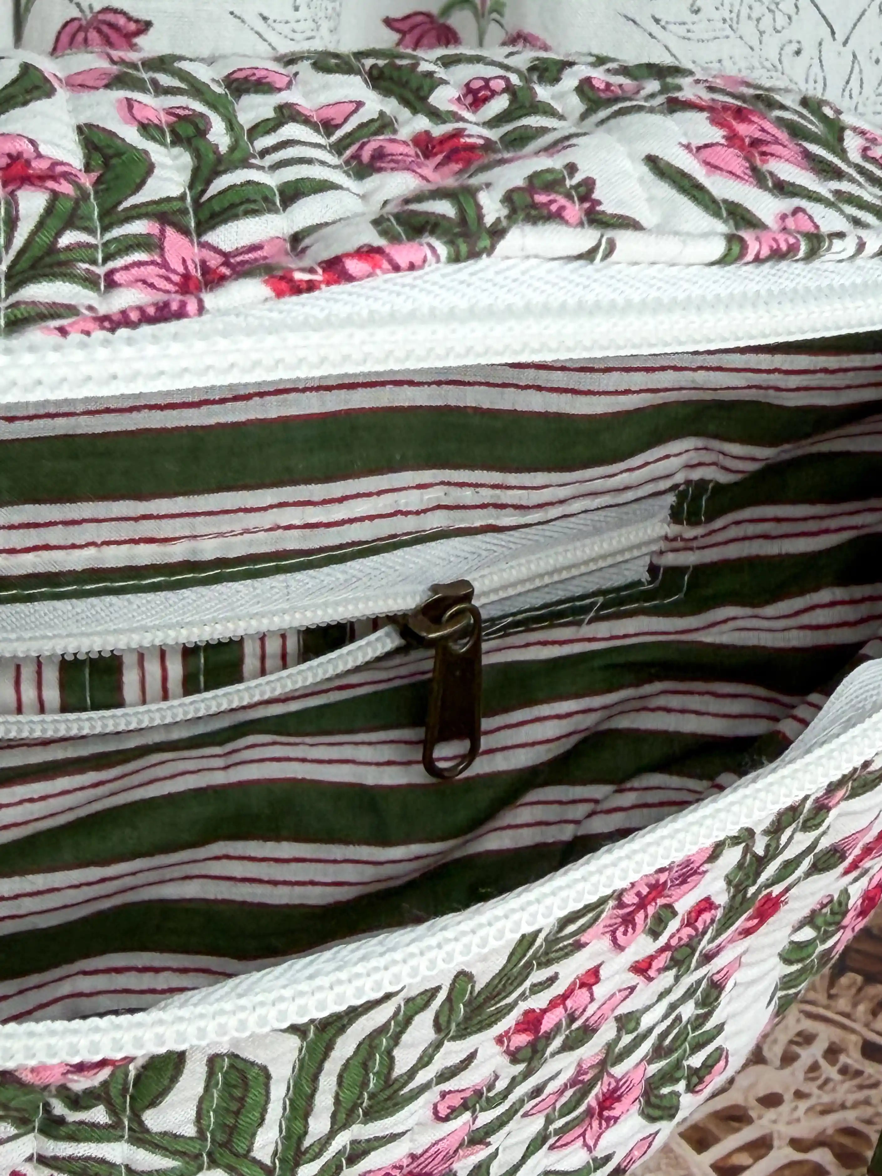 Cream quilted cotton fanny bag with red and green botanical floral hand block design, multicolor striped strap for hands-free everyday wear.