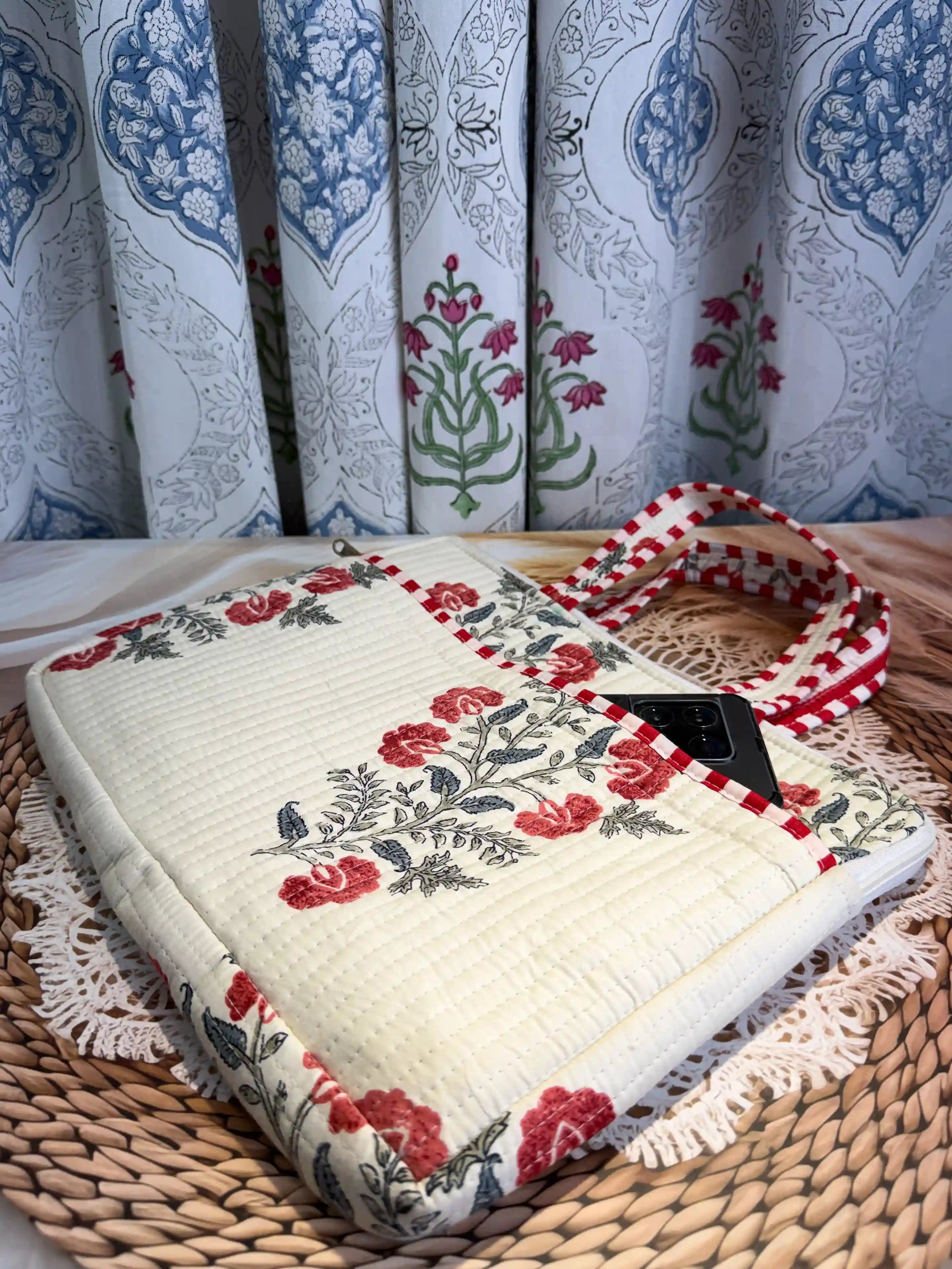 Cream quilted cotton laptop bag with red and green floral hand block design and dotted red borders, padded laptop cover for daily commute