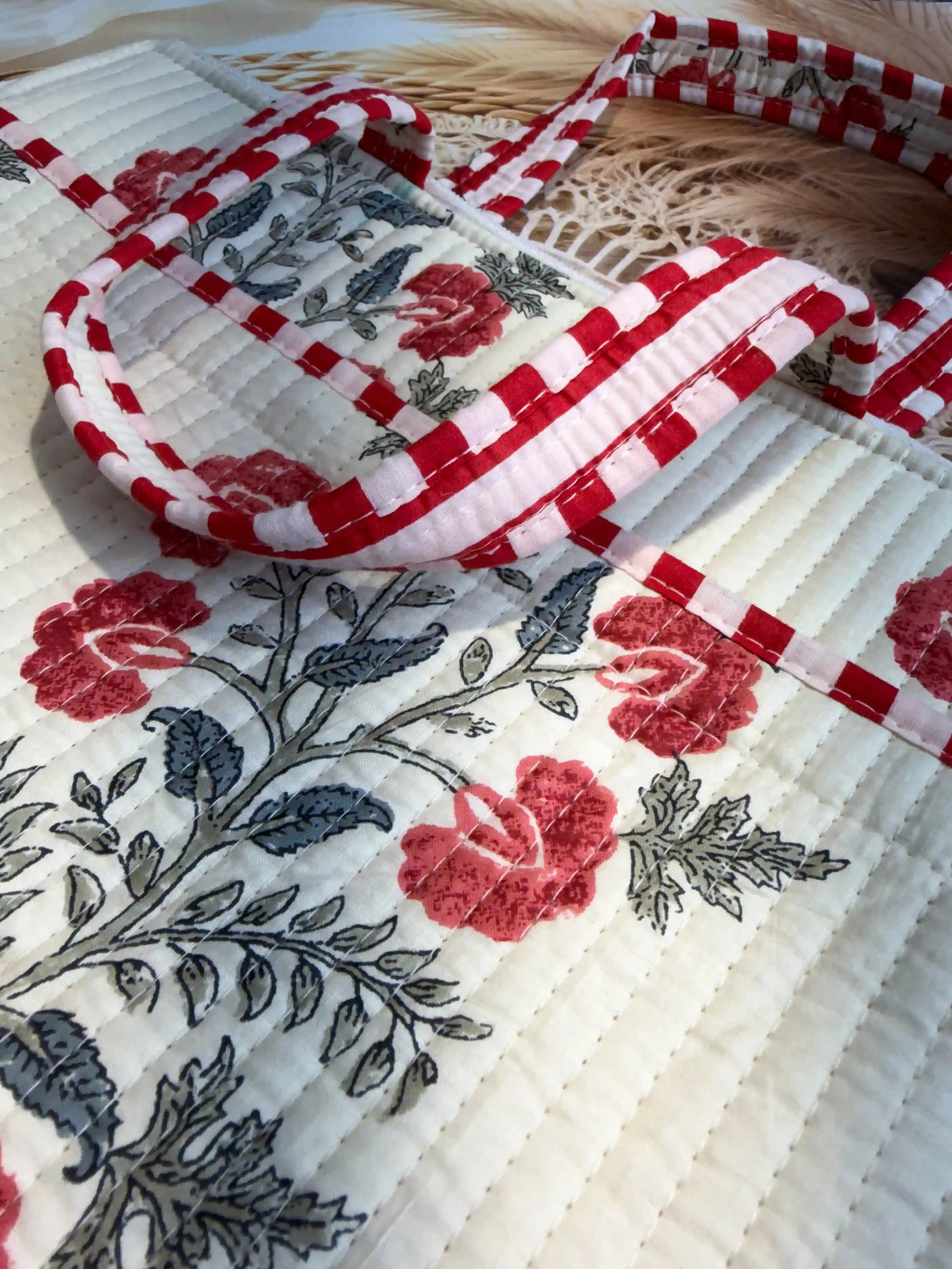Cream quilted cotton laptop bag with red and green floral hand block design and dotted red borders, padded laptop cover for daily commute