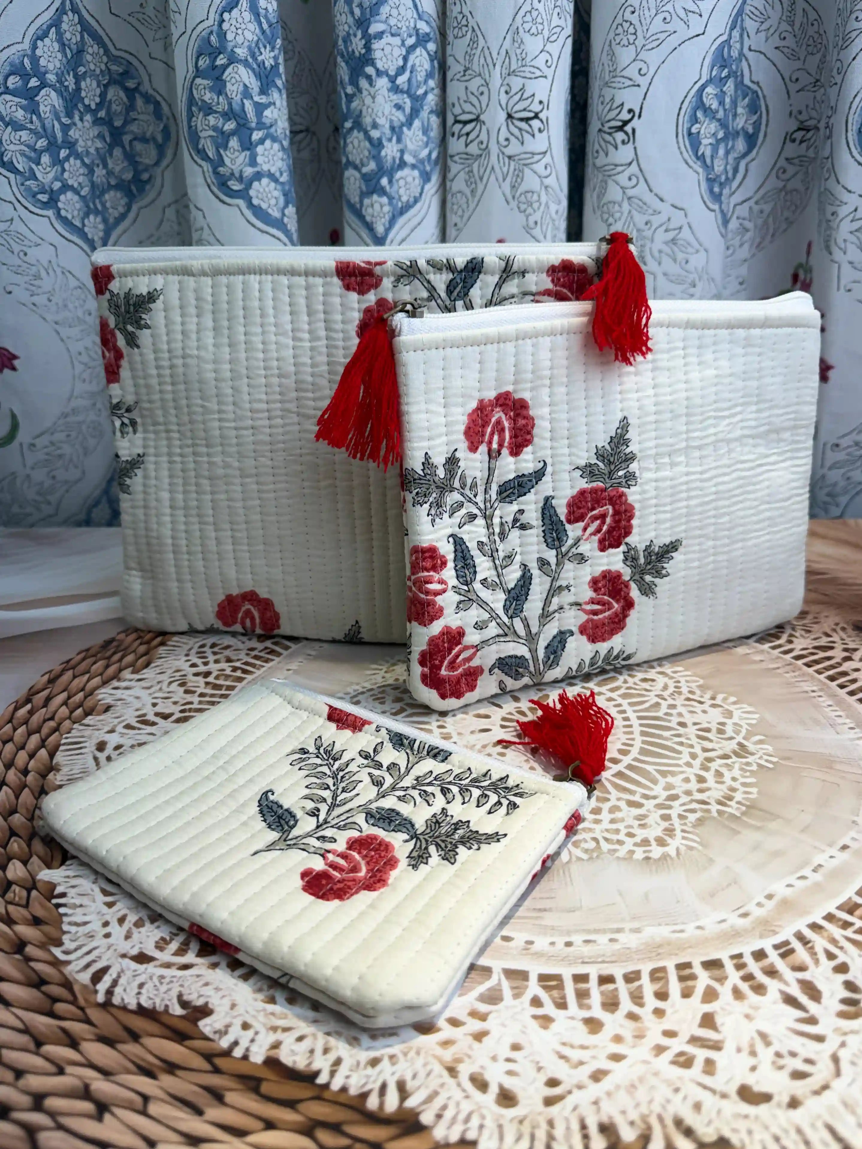 Cream quilted cotton flat pouch set with red botanical floral hand block design, three-piece handmade zipper organizer for daily grooming essentials.