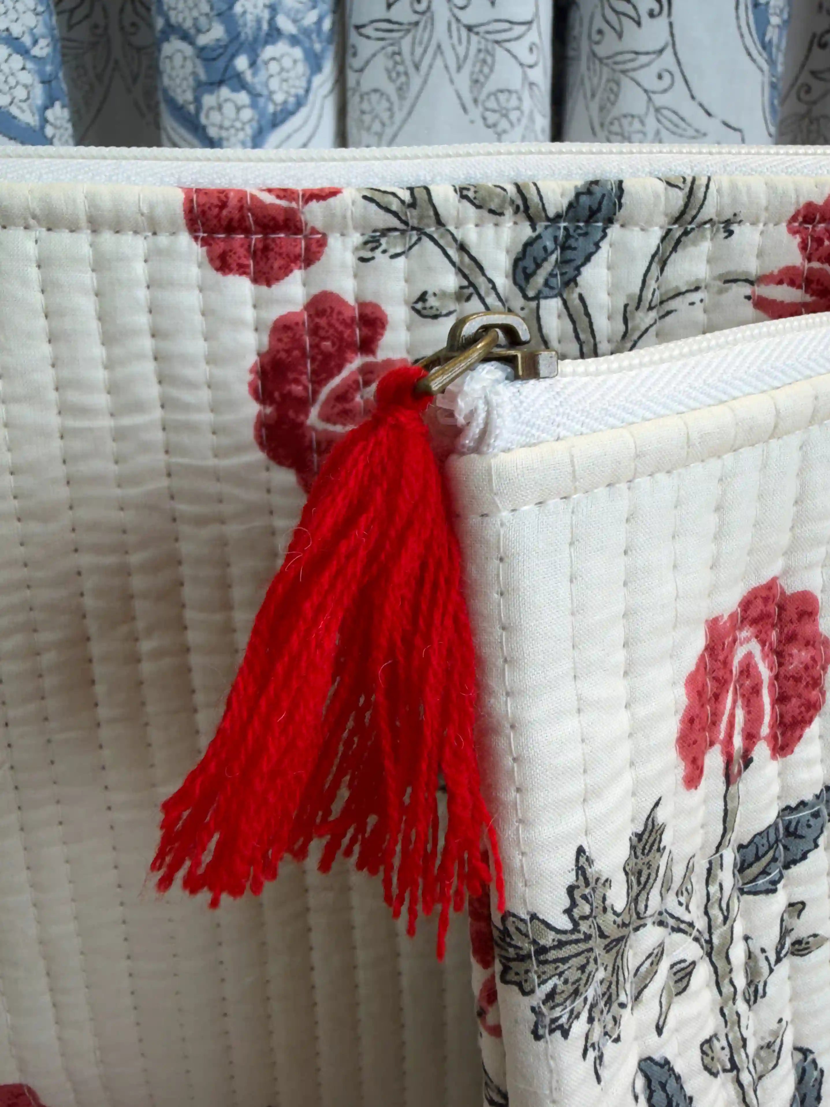 Cream quilted cotton flat pouch set with red botanical floral hand block design, three-piece handmade zipper organizer for daily grooming essentials.