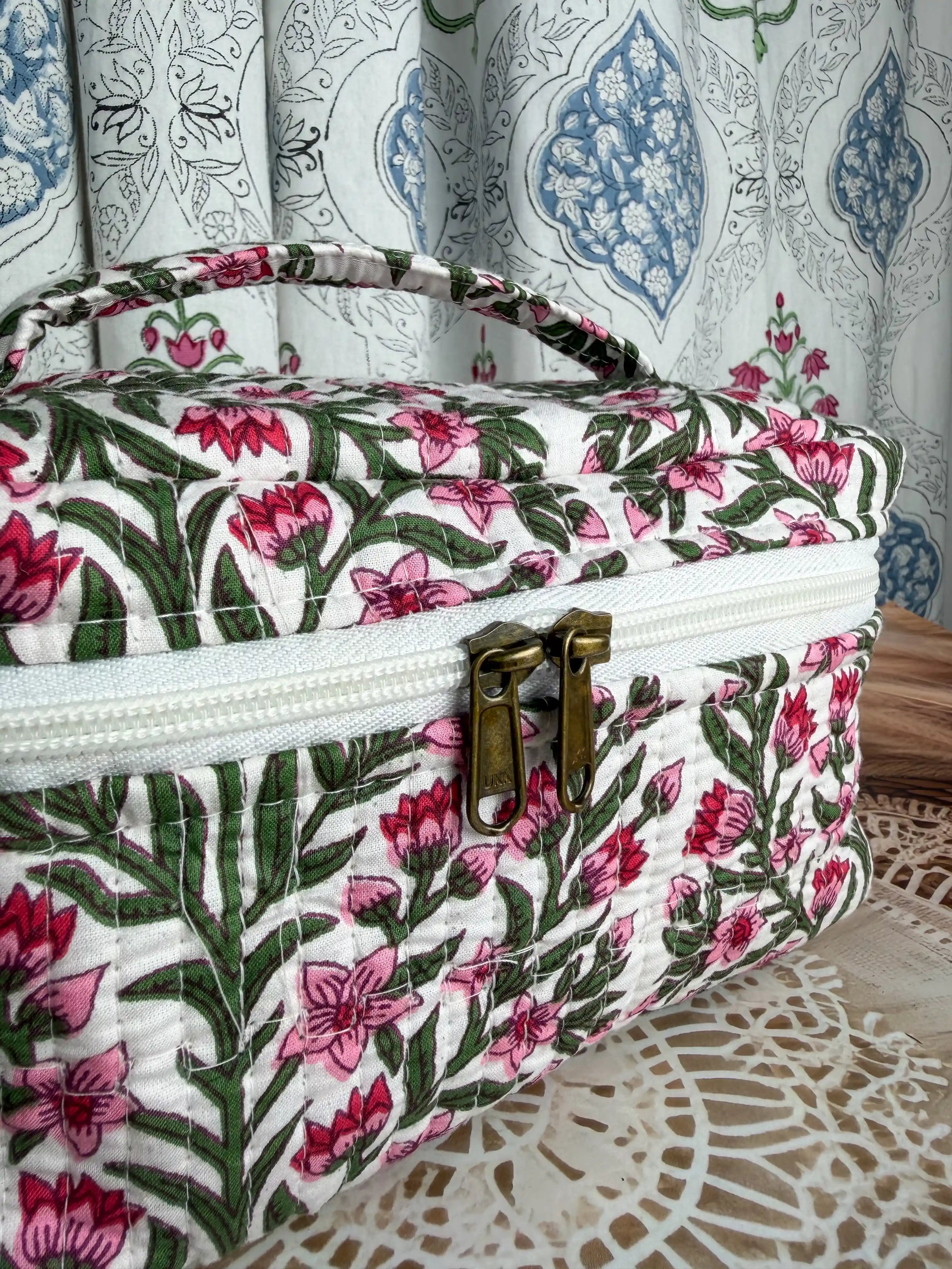 Cream quilted cotton cosmetic vanity bag with red and green botanical floral hand block print, compact handmade pouch ideal for cosmetics and toiletry storage.