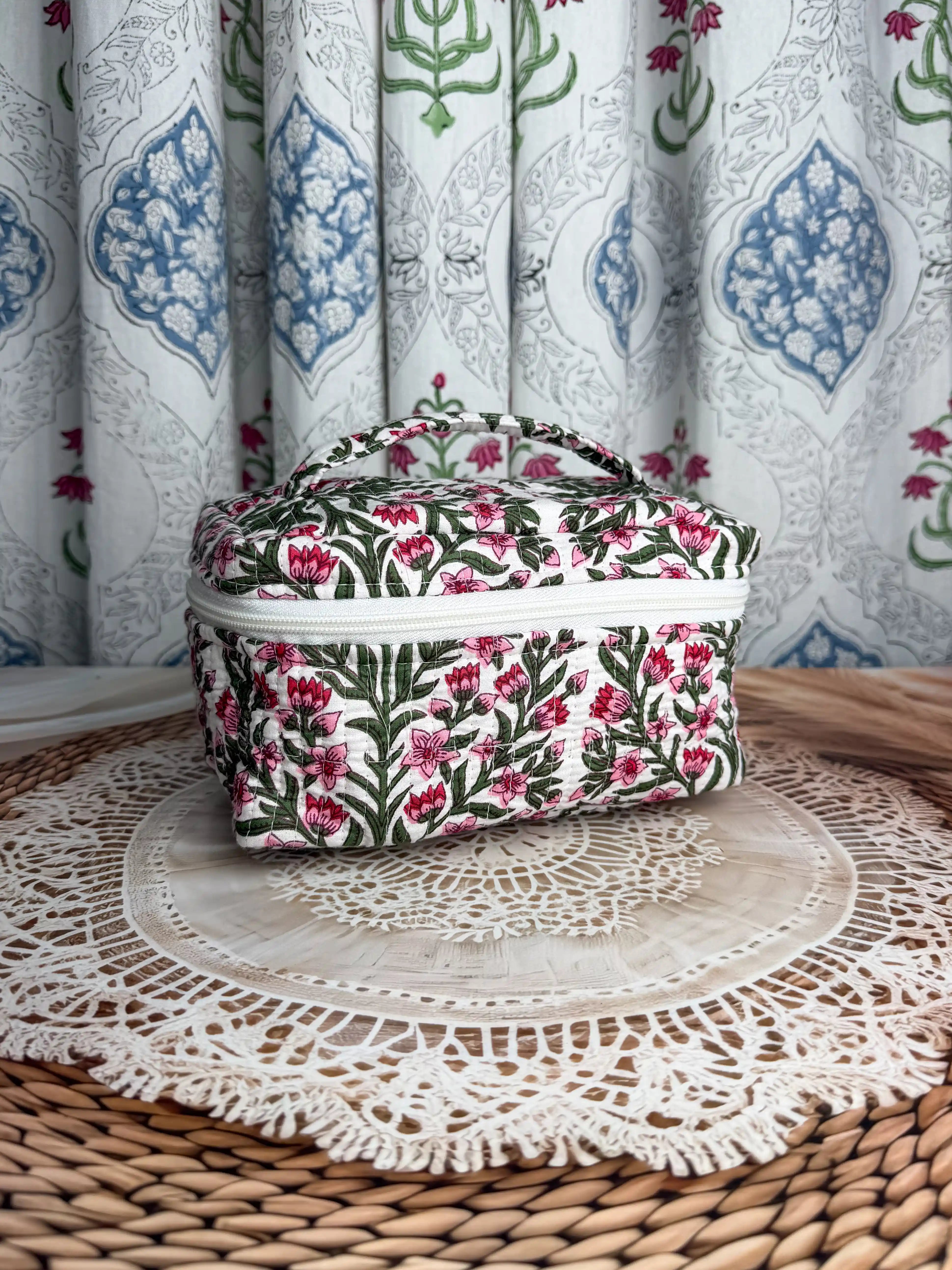 Cream quilted cotton cosmetic vanity bag with red and green botanical floral hand block print, compact handmade pouch ideal for cosmetics and toiletry storage.