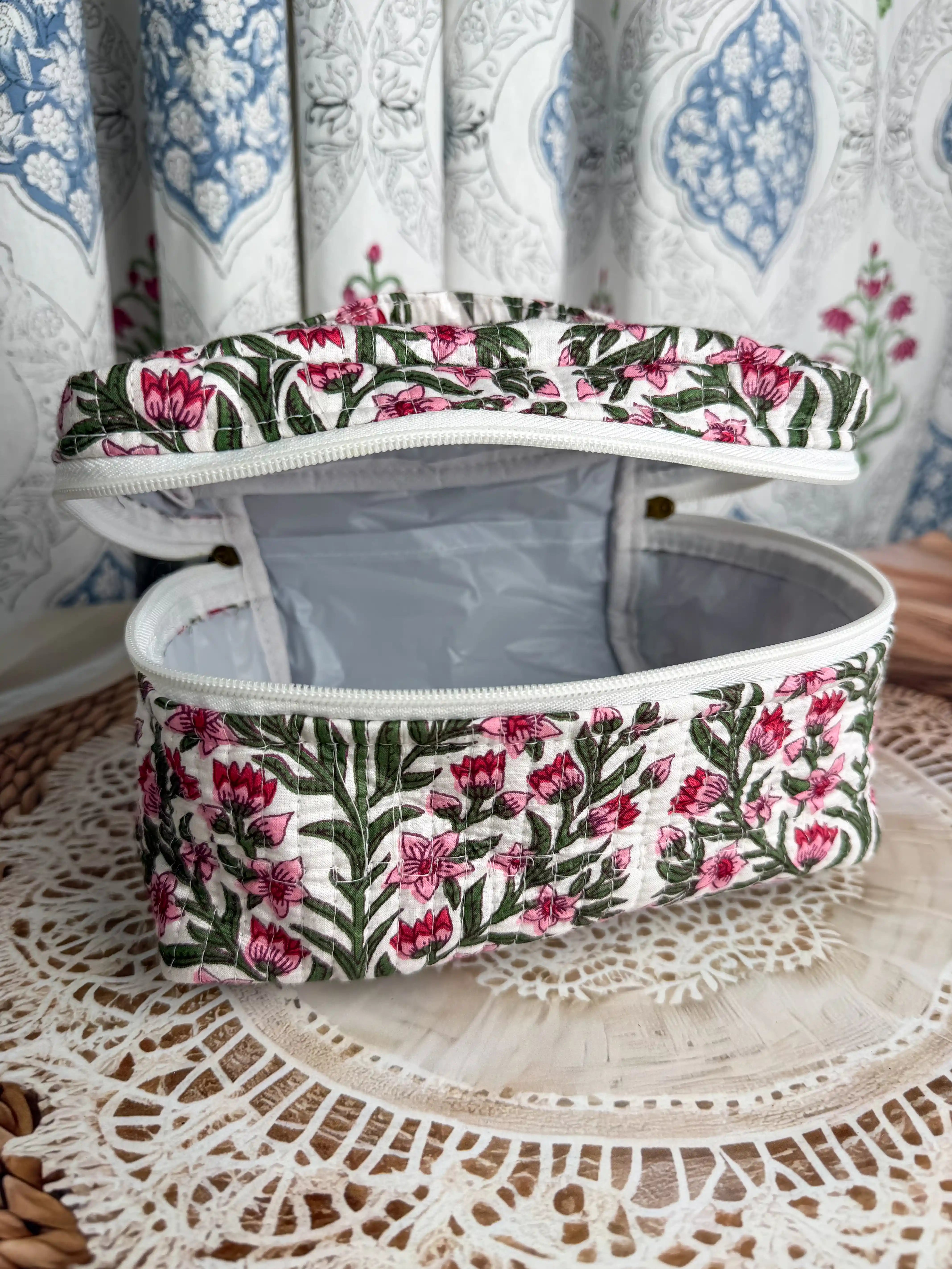 Cream quilted cotton cosmetic vanity bag with red and green botanical floral hand block print, compact handmade pouch ideal for cosmetics and toiletry storage.