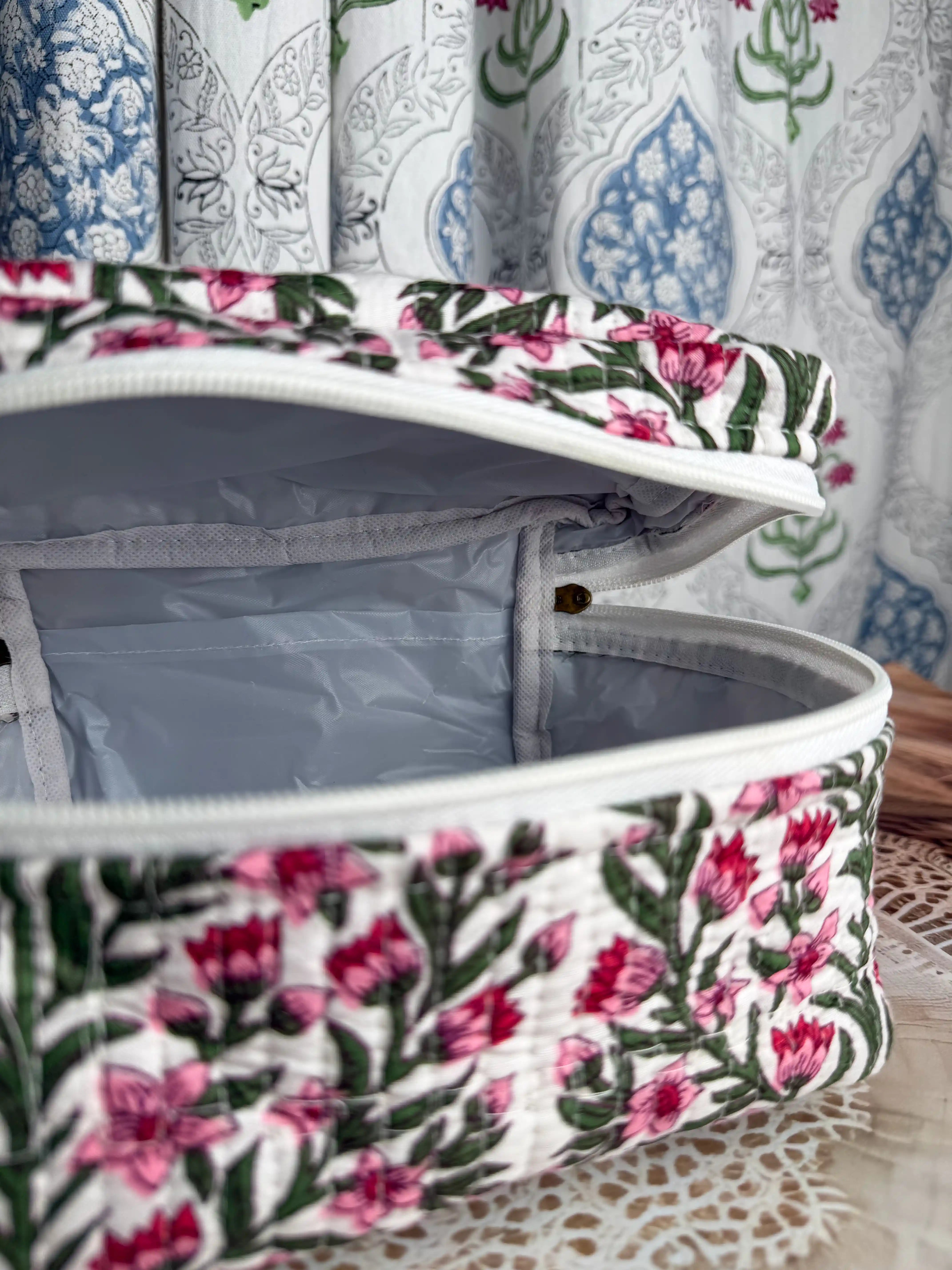 Cream quilted cotton cosmetic vanity bag with red and green botanical floral hand block print, compact handmade pouch ideal for cosmetics and toiletry storage.