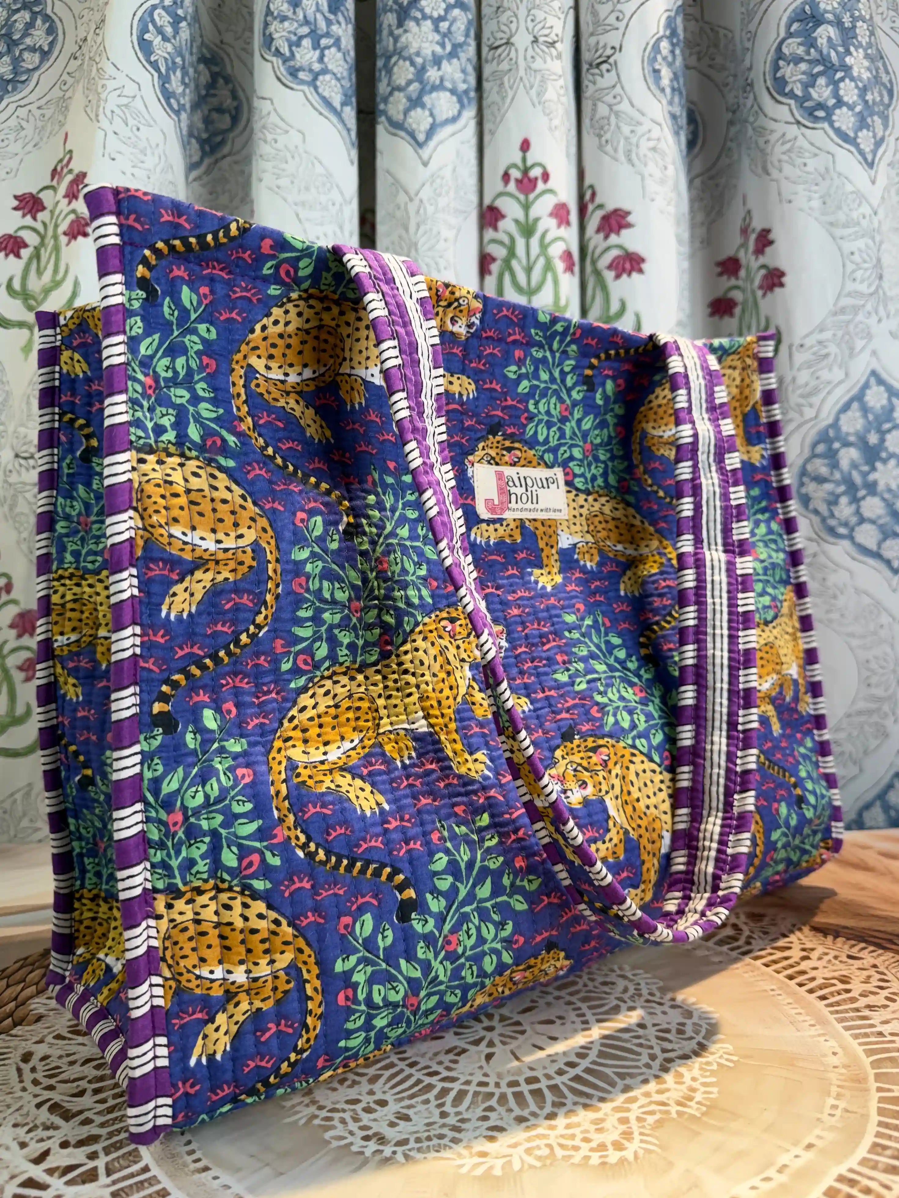 Deep blue quilted cotton open mini tote with yellow animal hand block print and green leaf accents, bold statement mini shoulder bag for travel.
