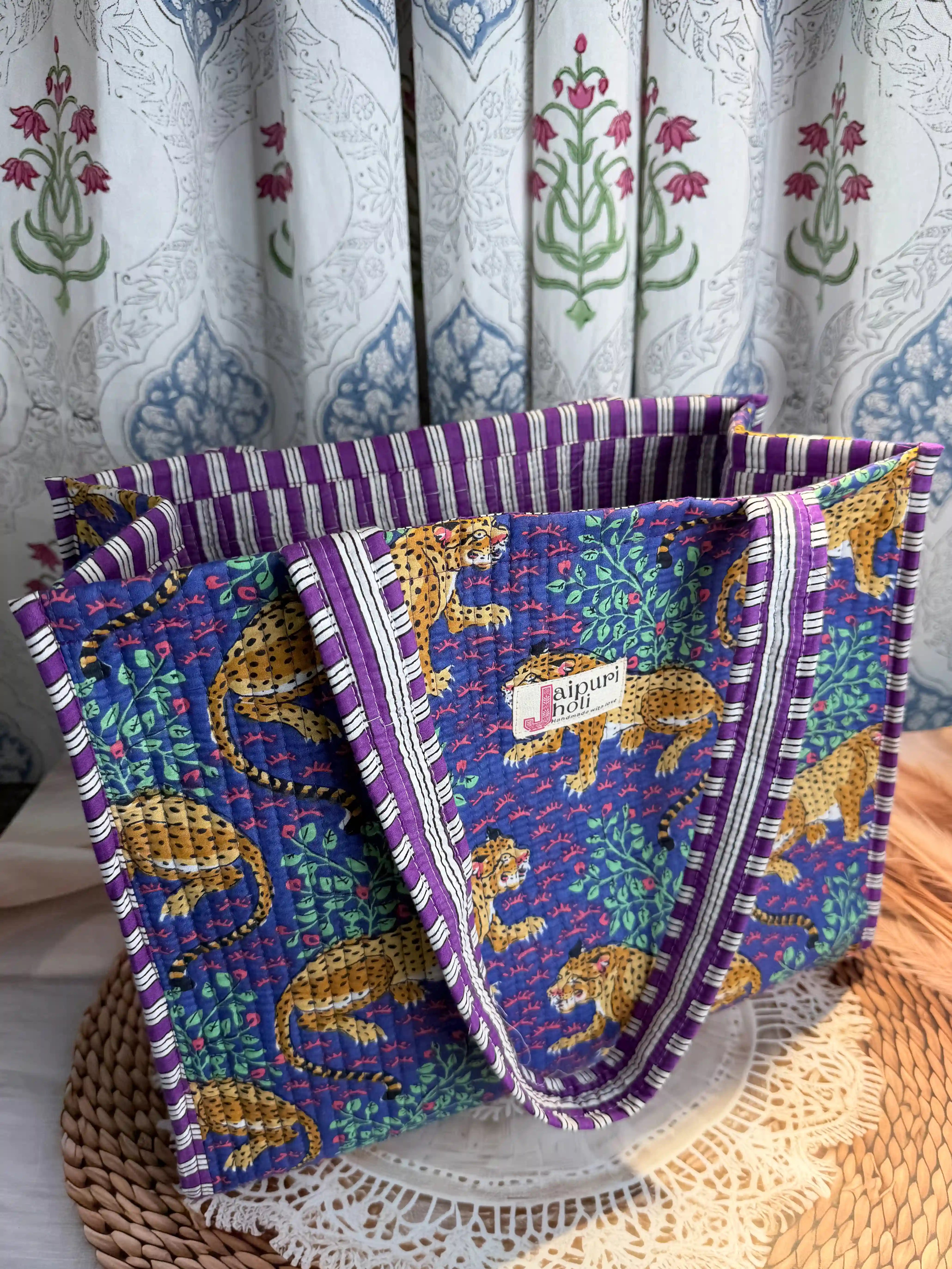 Deep blue quilted cotton open mini tote with yellow animal hand block print and green leaf accents, bold statement mini shoulder bag for travel.