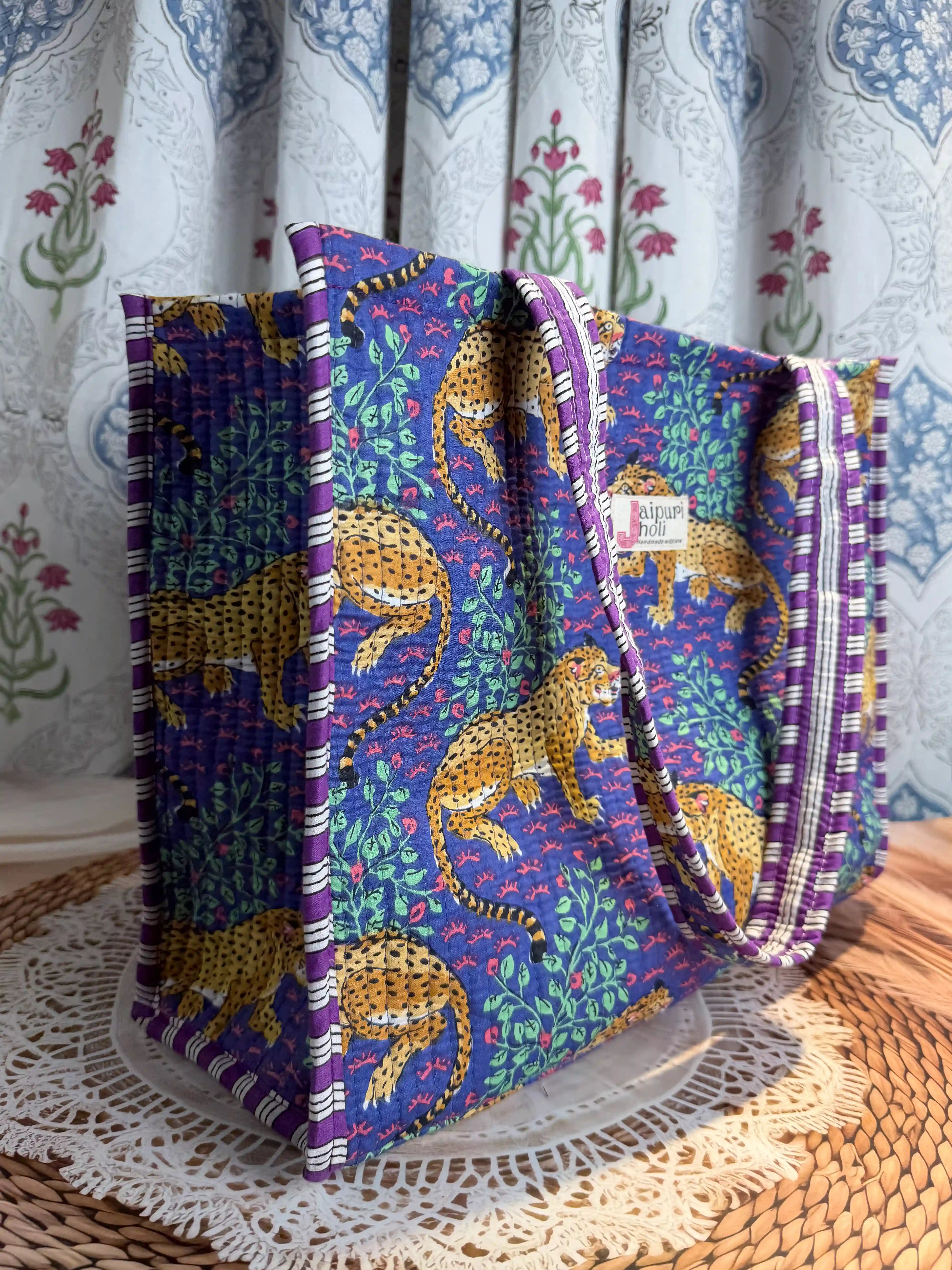 Deep blue quilted cotton open mini tote with yellow animal hand block print and green leaf accents, bold statement mini shoulder bag for travel.