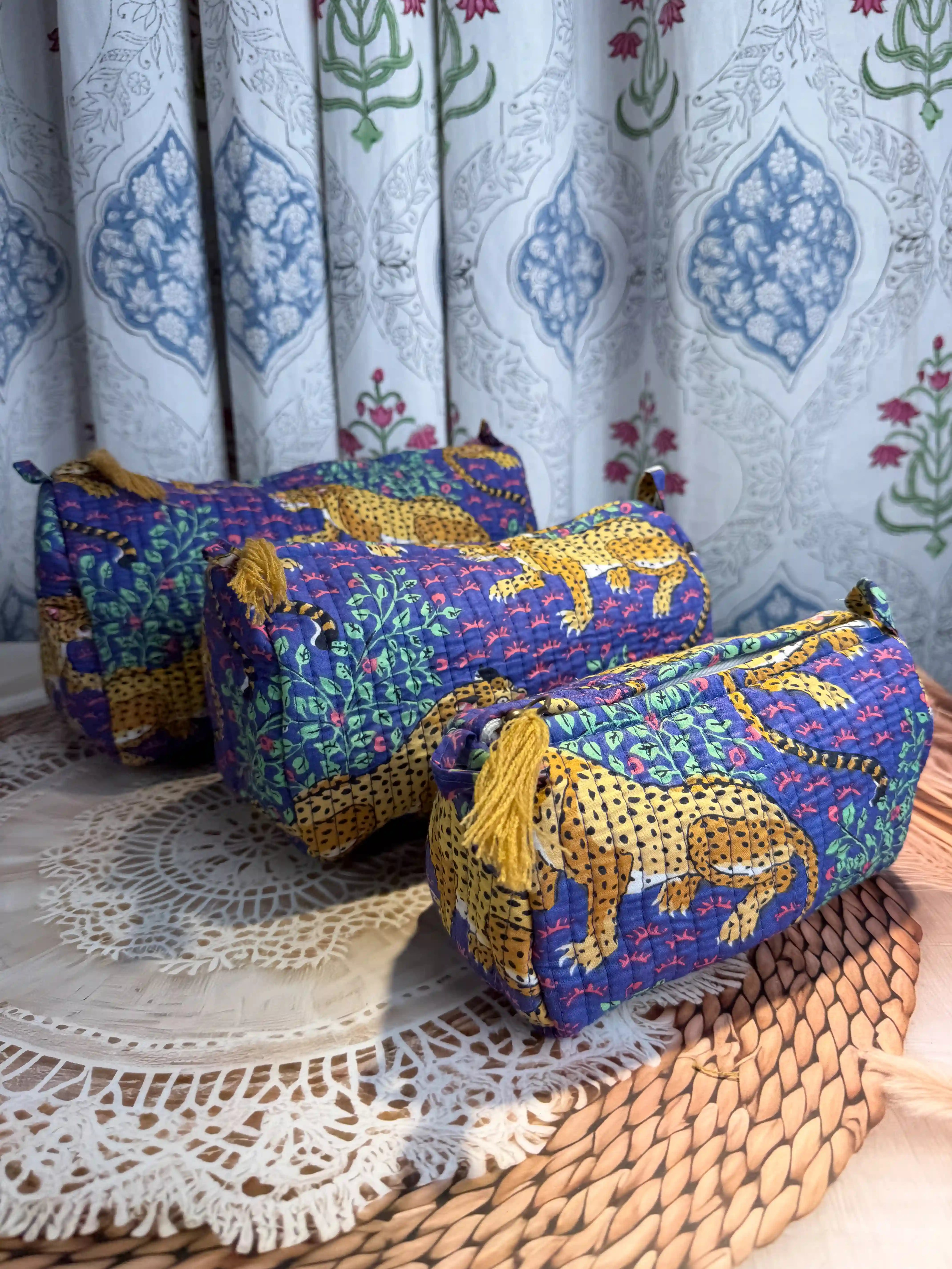 Deep blue quilted cotton toiletry pouch set with yellow leopard print hand block design, animal print three-piece organizer for bathroom essentials.