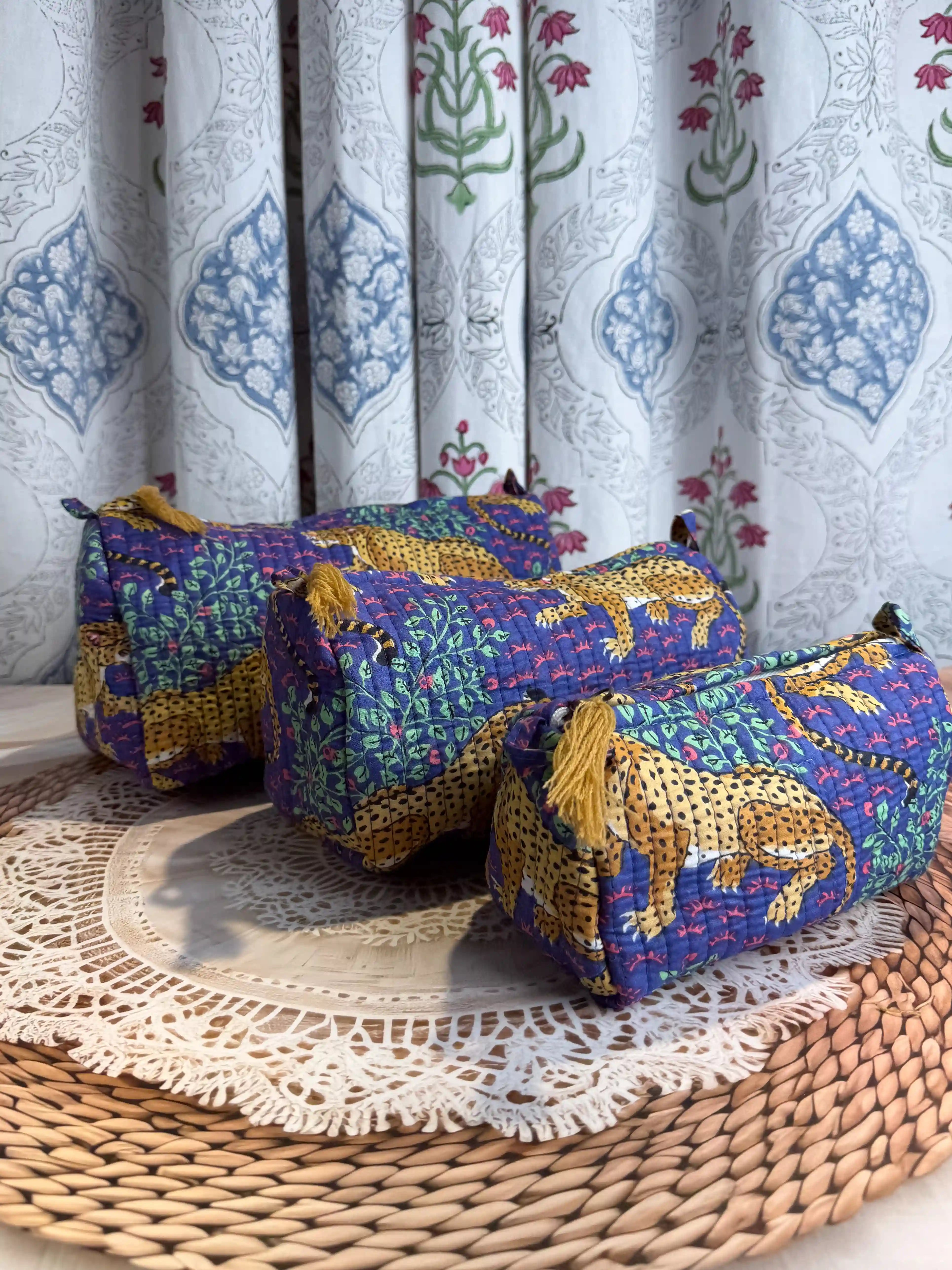 Deep blue quilted cotton toiletry pouch set with yellow leopard print hand block design, animal print three-piece organizer for bathroom essentials.