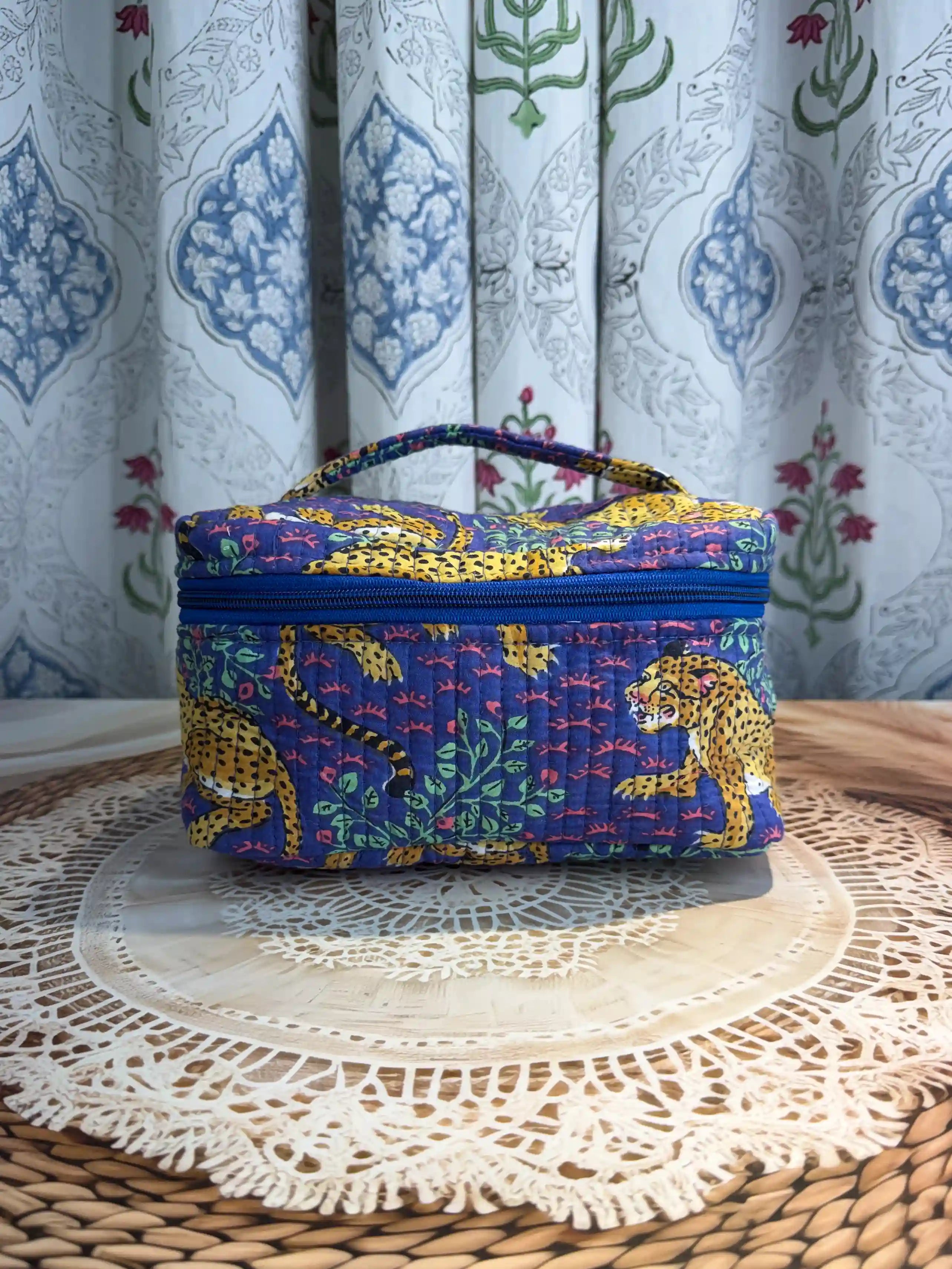 Deep blue quilted cotton cosmetic vanity bag with yellow print hand block design, animal print padded organizer for makeup storage and travel.