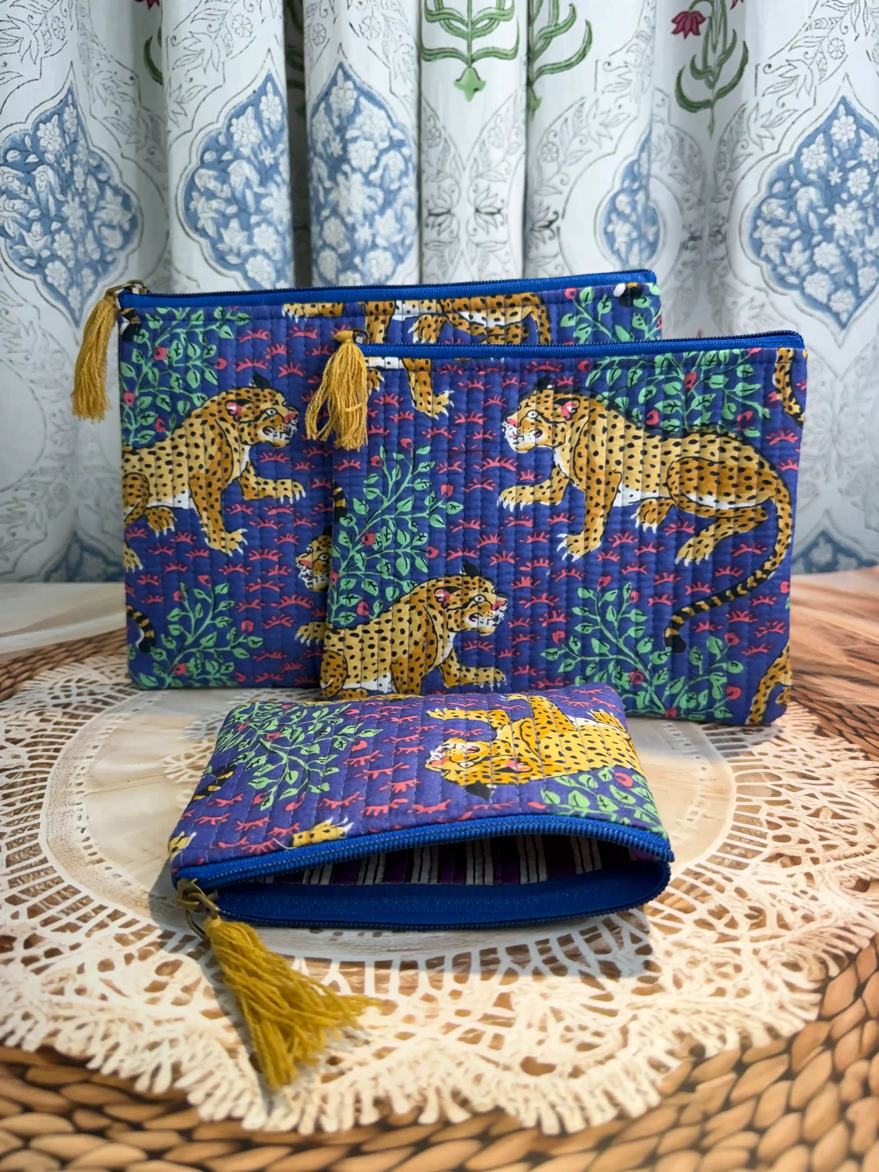 Deep blue quilted cotton flat pouch set with yellow leopard print hand block design, animal print three-piece zipper organizer for travel essentials.