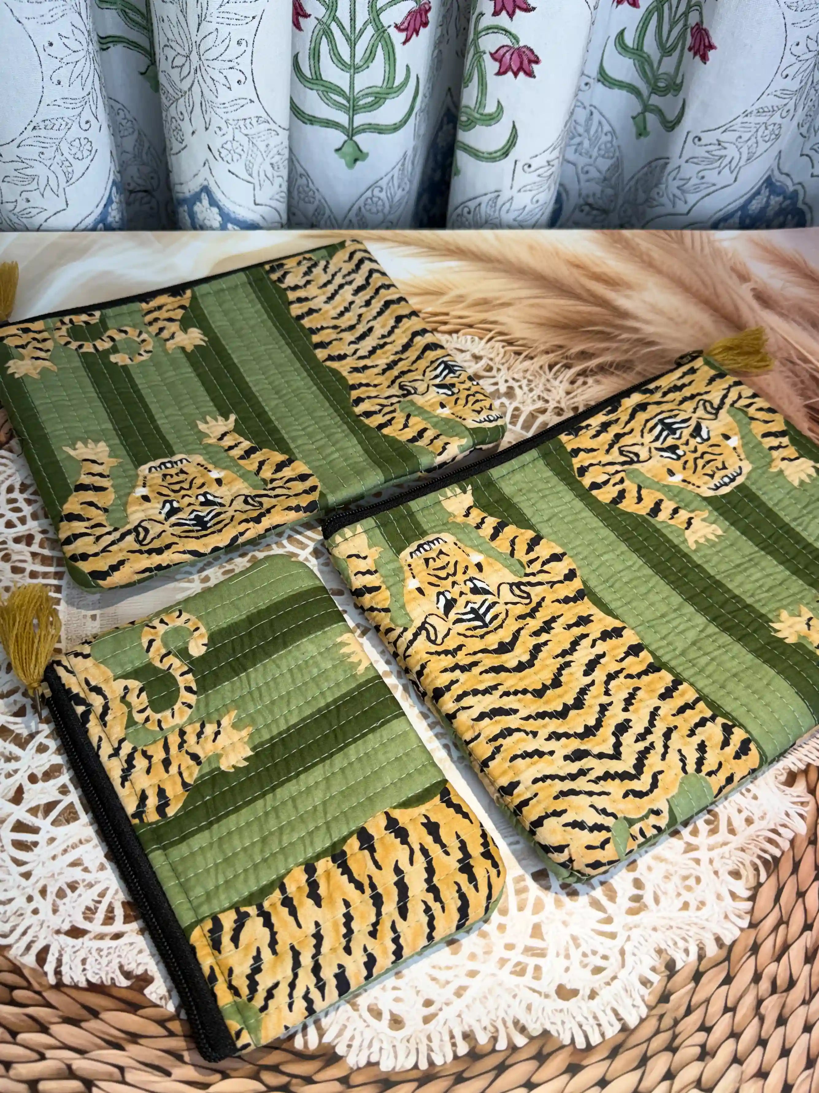 Green quilted cotton flat pouch set with yellow animal print hand block pattern, three-piece lightweight handcrafted zipper pouches for organization.