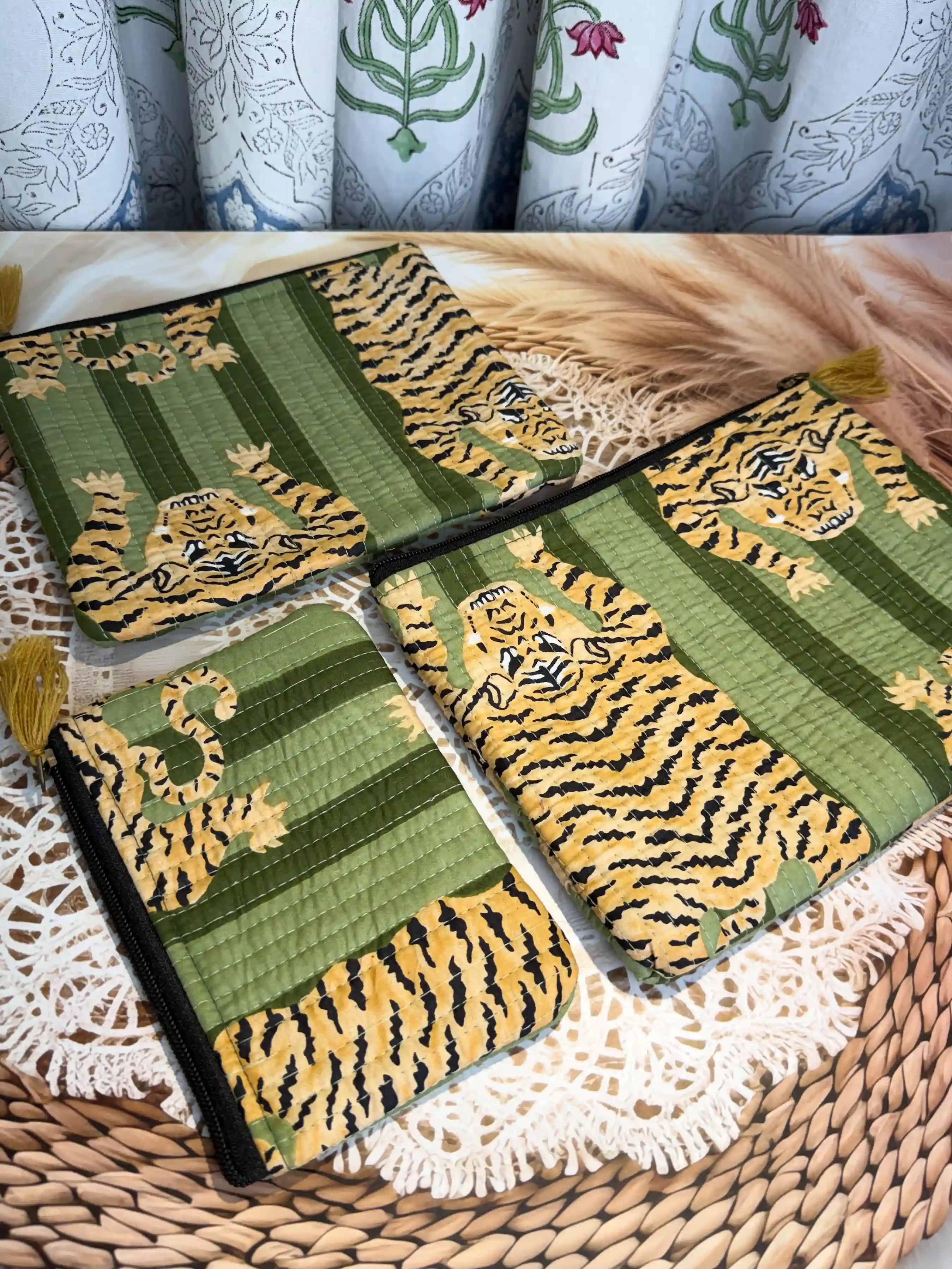 Green quilted cotton flat pouch set with yellow animal print hand block pattern, three-piece lightweight handcrafted zipper pouches for organization.