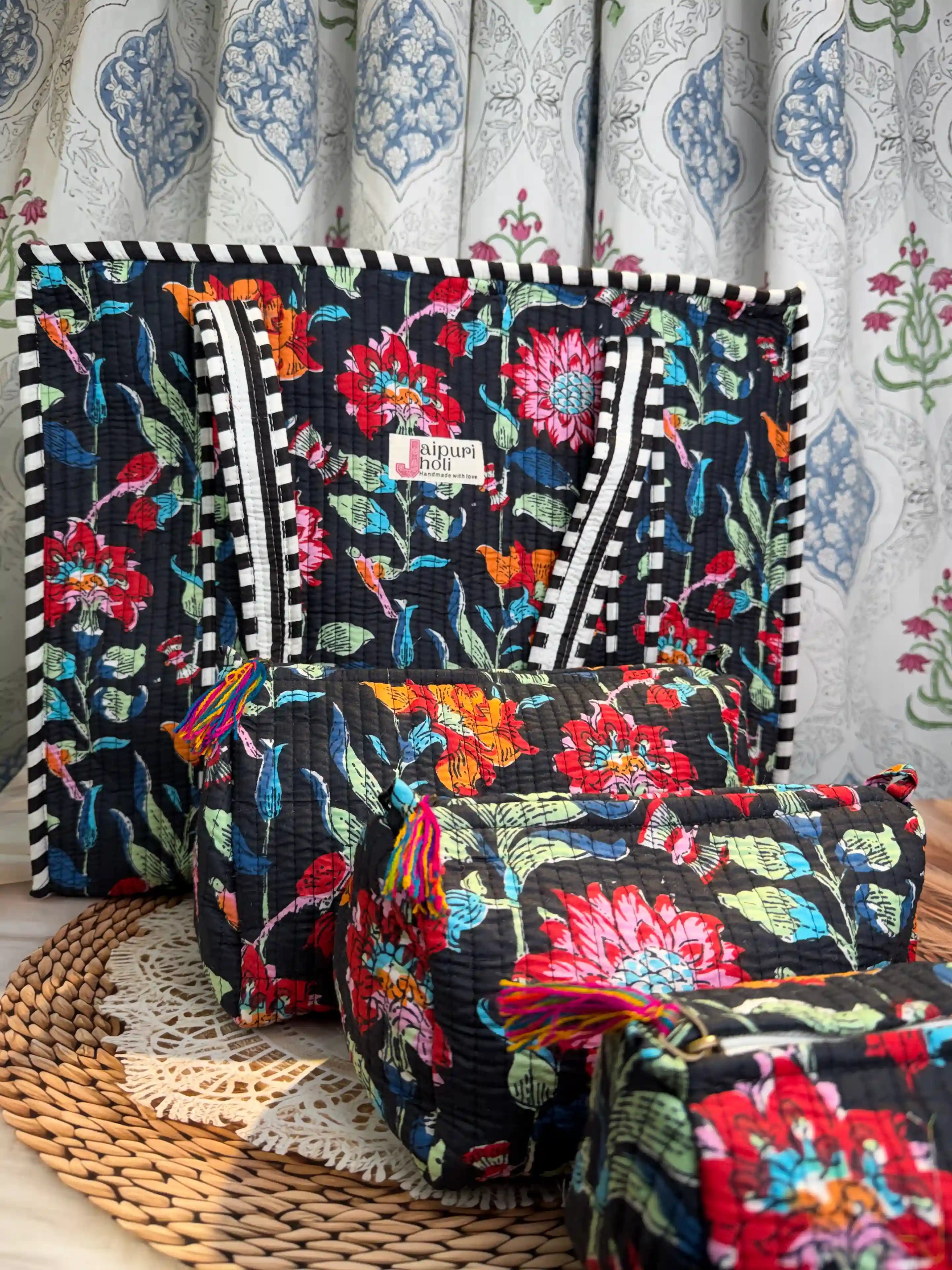 Handcrafted floral print cotton quilted tote bag with sturdy handles and matching 3-piece zippered toiletry pouch set, featuring vibrant multicolor flowers on dark base, ethically made in Jaipur, India, ideal for everyday use, travel, cosmetics, skincare, and innerwear storage