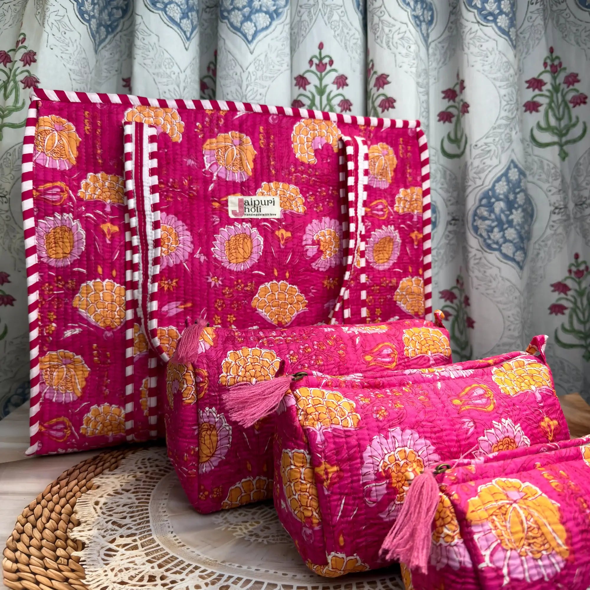 Handcrafted pink floral cotton quilted tote bag with sturdy striped handles and matching 3-piece zippered toiletry pouch set, featuring vibrant ethnic floral print and soft quilted finish, ethically made in Jaipur, India, ideal for everyday use, travel, cosmetics, skincare, and innerwear storage
