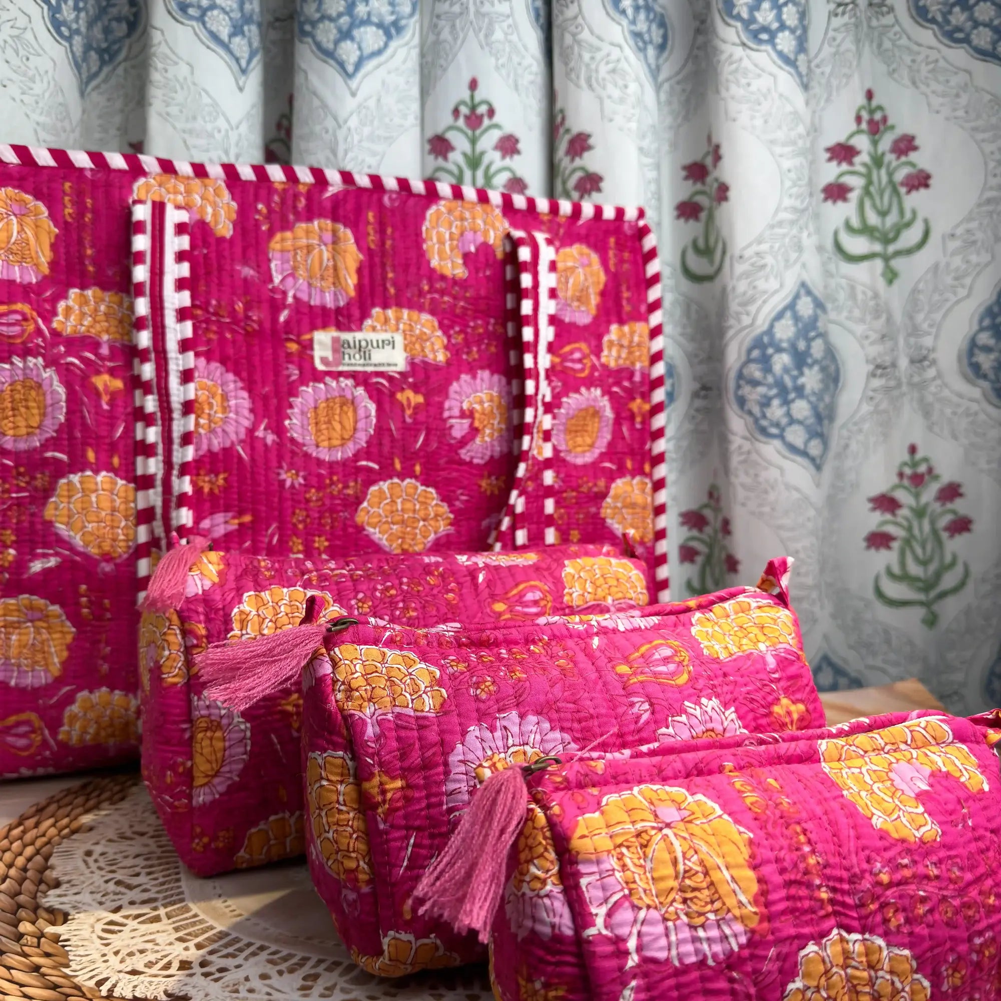 Handcrafted pink floral cotton quilted tote bag with sturdy striped handles and matching 3-piece zippered toiletry pouch set, featuring vibrant ethnic floral print and soft quilted finish, ethically made in Jaipur, India, ideal for everyday use, travel, cosmetics, skincare, and innerwear storage