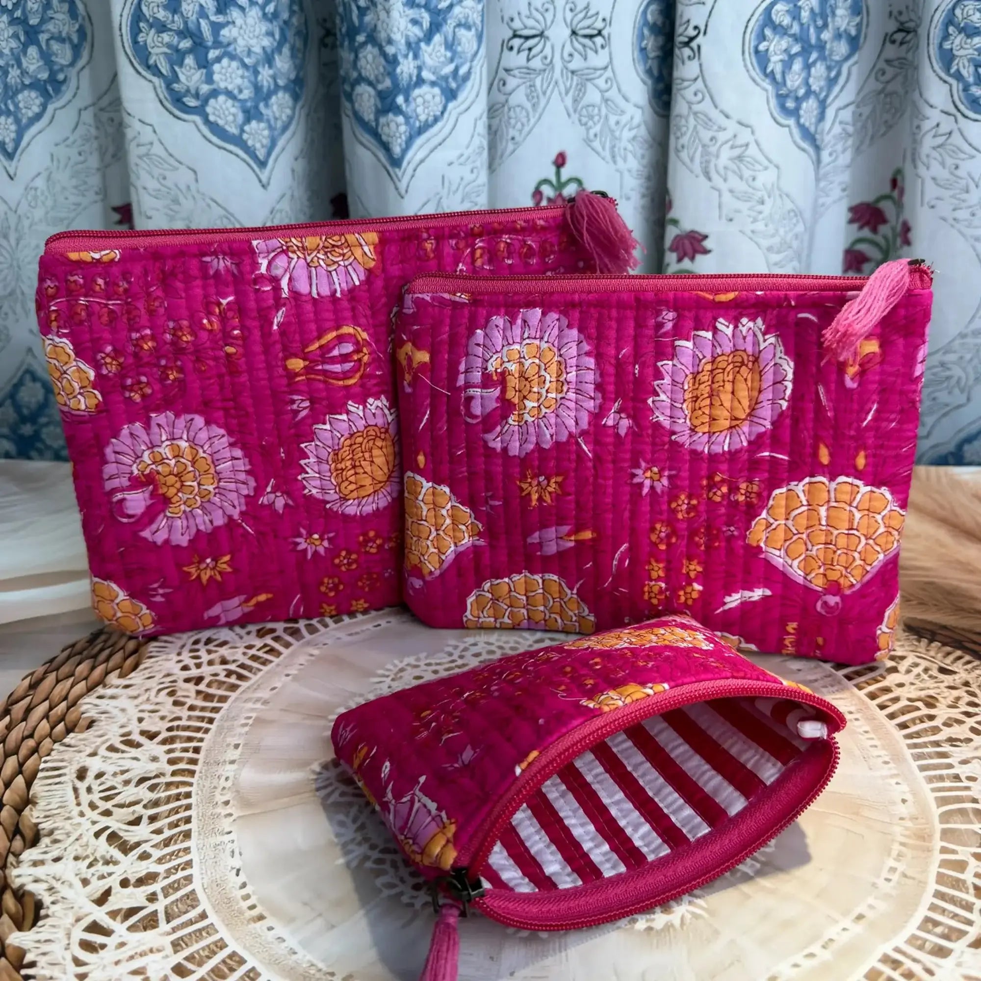 Pink quilted cotton flat pouch set with red and yellow multicolor floral hand block design, three-piece lightweight handmade zipper pouches for daily use.