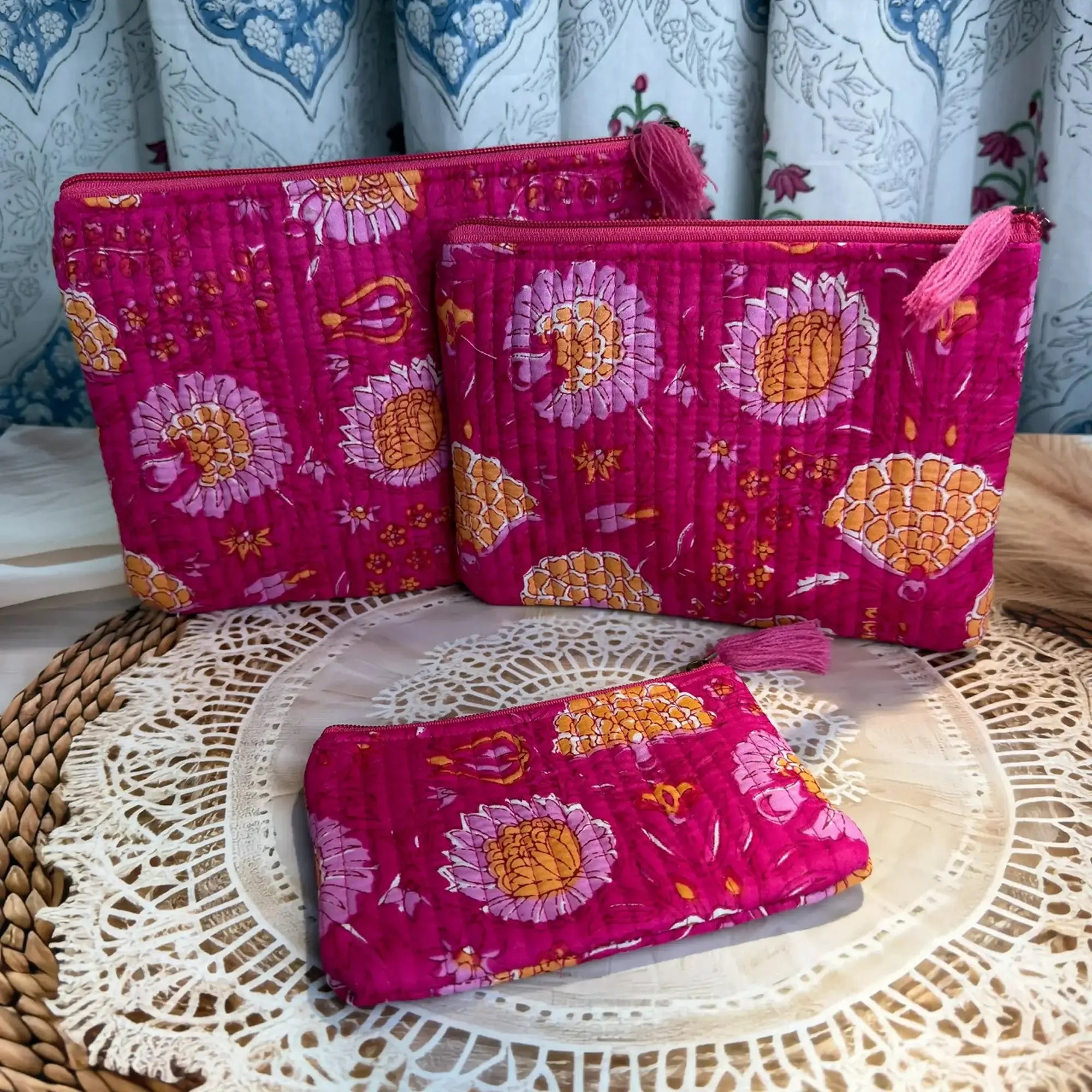 Pink quilted cotton flat pouch set with red and yellow multicolor floral hand block design, three-piece lightweight handmade zipper pouches for daily use.