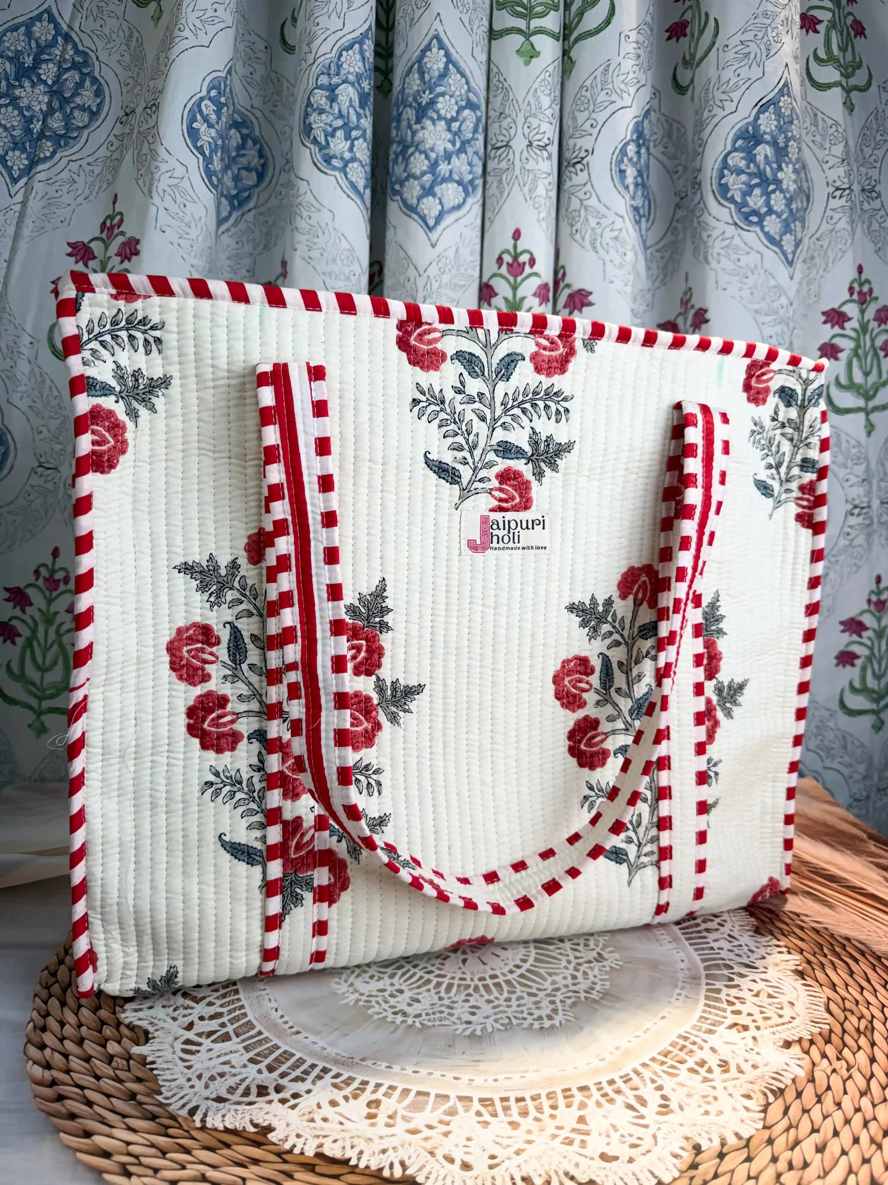 White quilted cotton tote bag with red floral hand block design, red and white striped borders, and zip, premium shoulder tote for daily use.