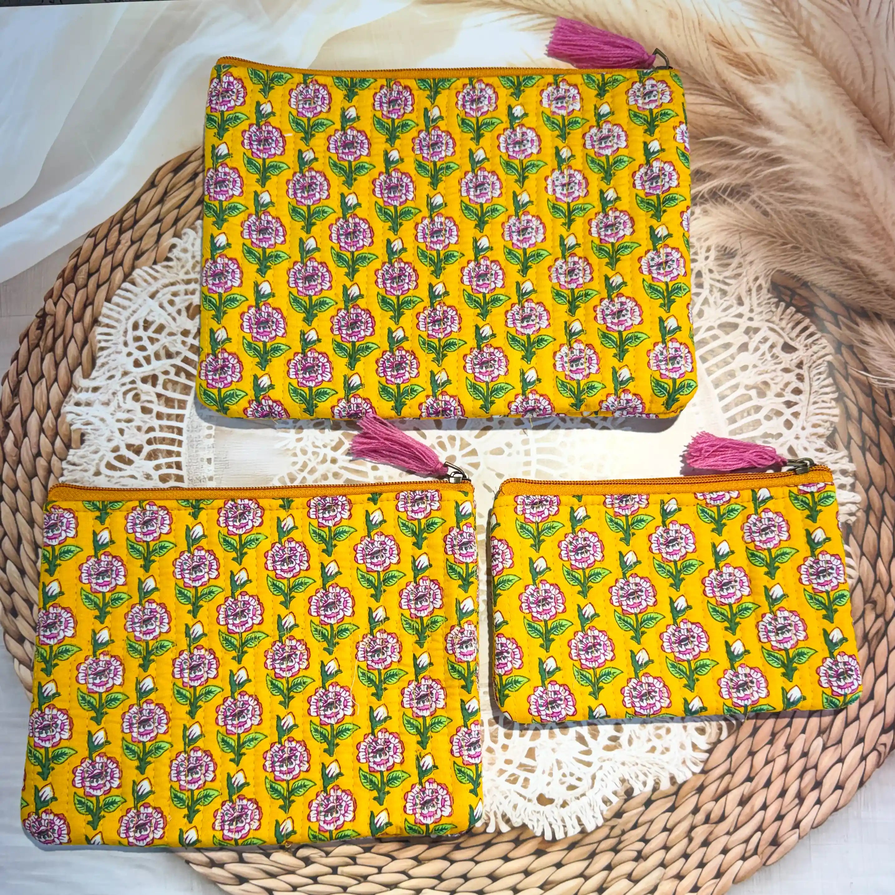 Bright yellow quilted cotton flat pouch set with multicolor floral hand block design, three-piece lightweight handcrafted zipper organizer for daily essentials.