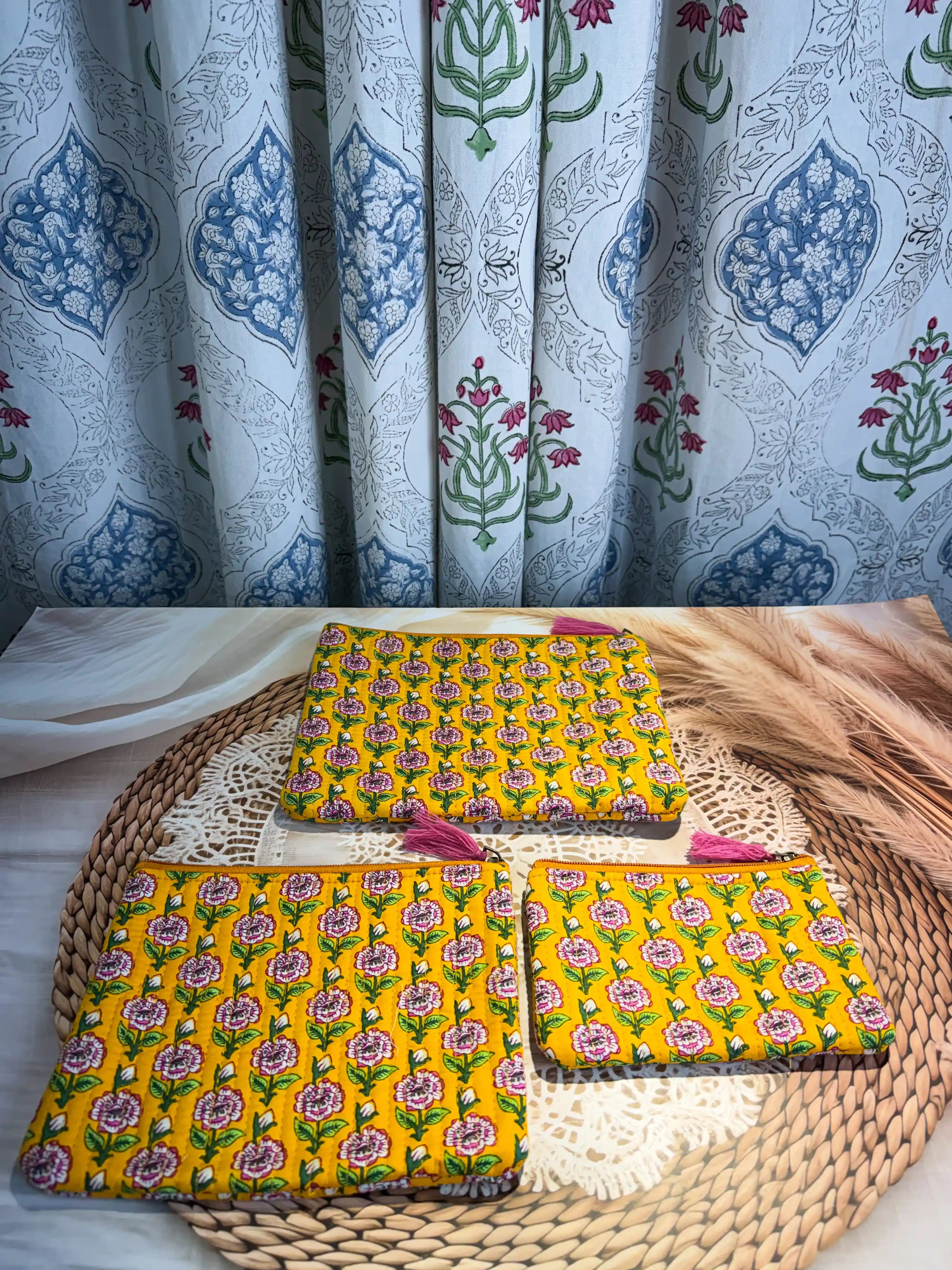 Bright yellow quilted cotton flat pouch set with multicolor floral hand block design, three-piece lightweight handcrafted zipper organizer for daily essentials.