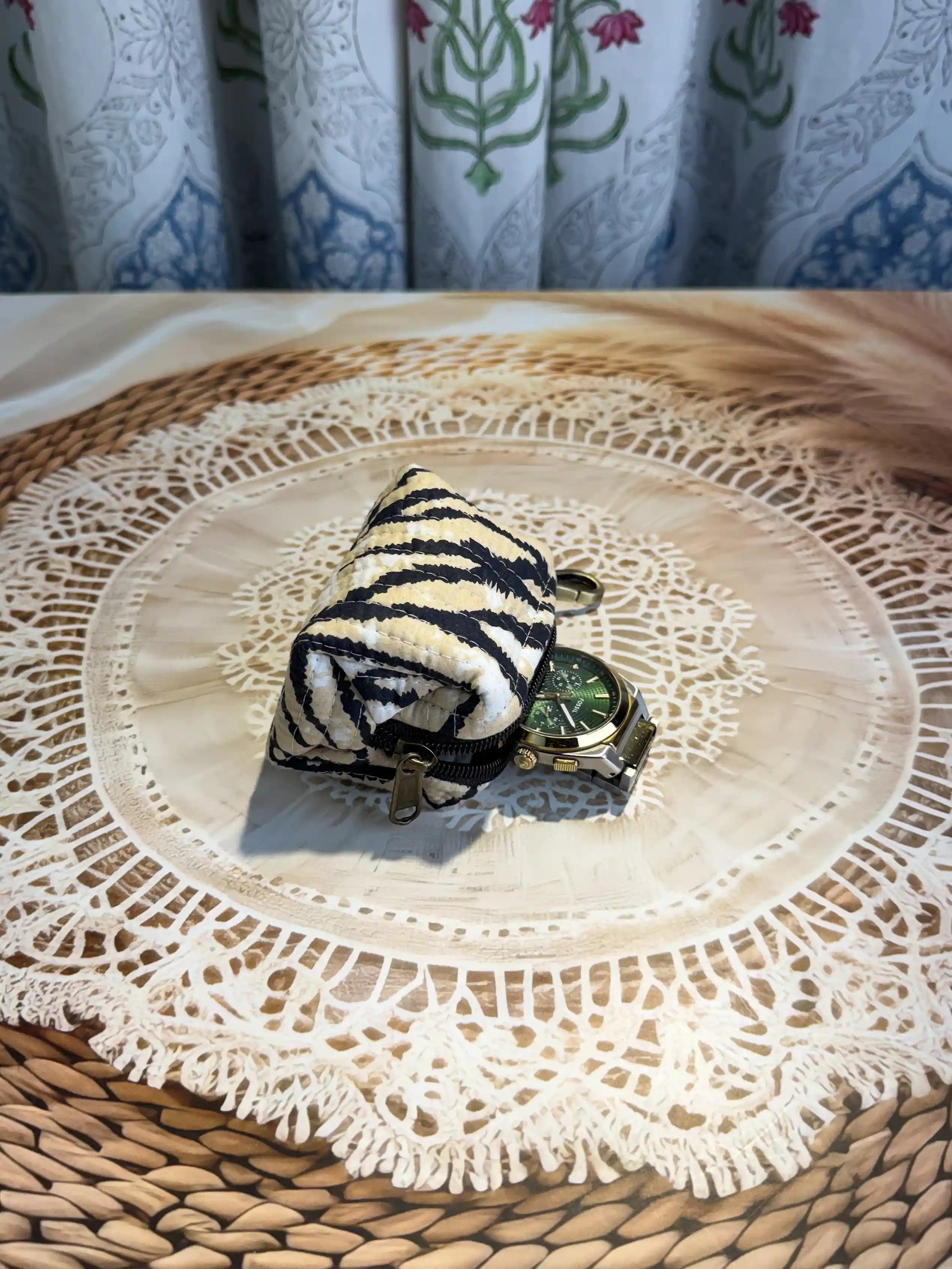Trending animal print quilted cotton mini pouch with black animal stripes on white background, hand block printed with zipper closure and brass keyring attachment.
