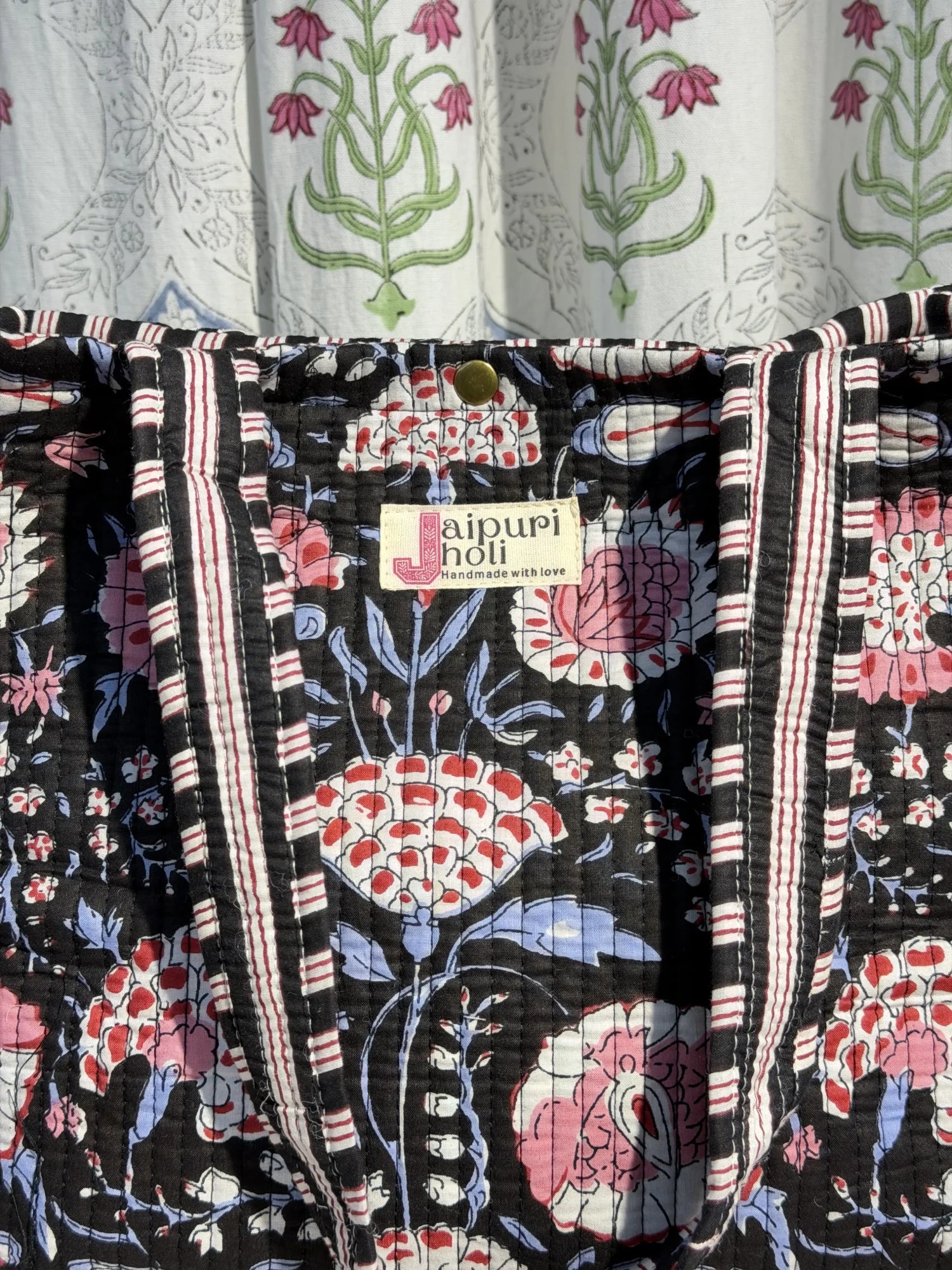 Jaipur block print cotton quilted medium reversible tote bag with matching flat pouch, black and pink floral print, 15 × 12 × 6 inch tote and 9 × 7 inch flat pouch for work, shopping and travel close-up view