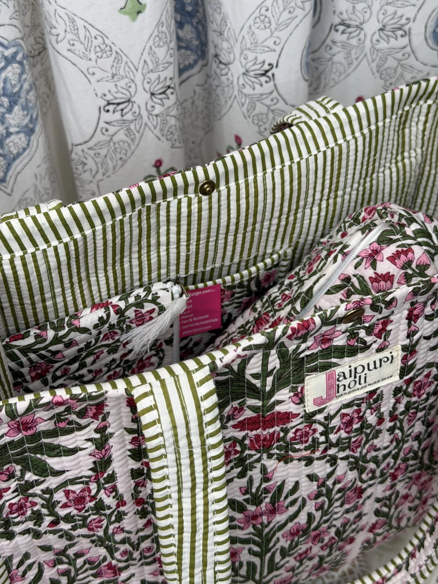 Jaipur block print cotton quilted medium reversible tote bag with matching flat pouch, pink floral and green leaf print, 15 × 12 × 6 inch tote and 9 × 7 inch flat pouch for travel, shopping and work side view