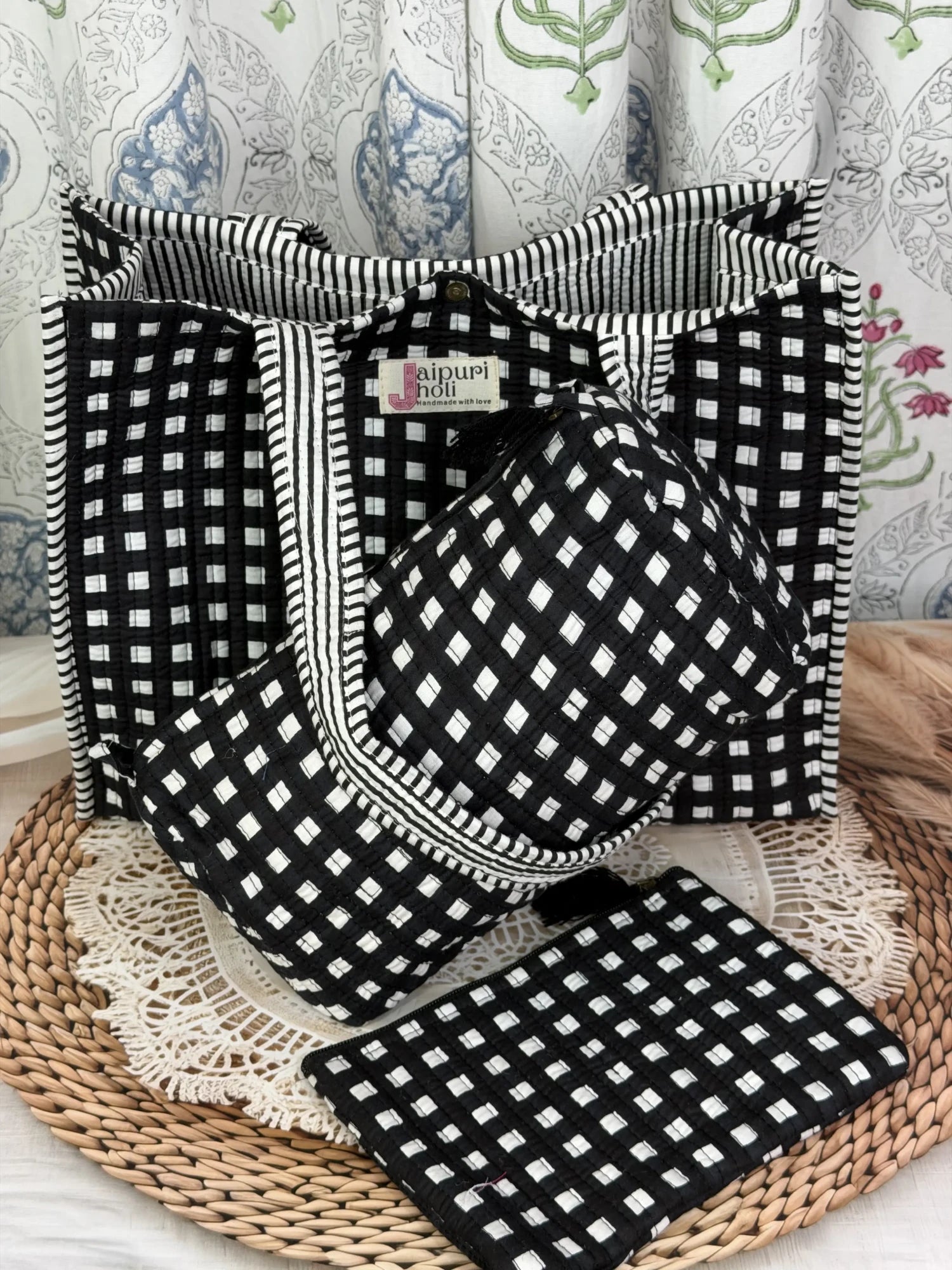 Jaipur block print medium cotton quilted reversible tote bag with matching toiletry pouch and flat pouch, black and white geometric check print, 15 × 12 × 6 inch tote with button closure, 10 × 6 inch toiletry pouch and 9 × 7 inch flat pouch side view